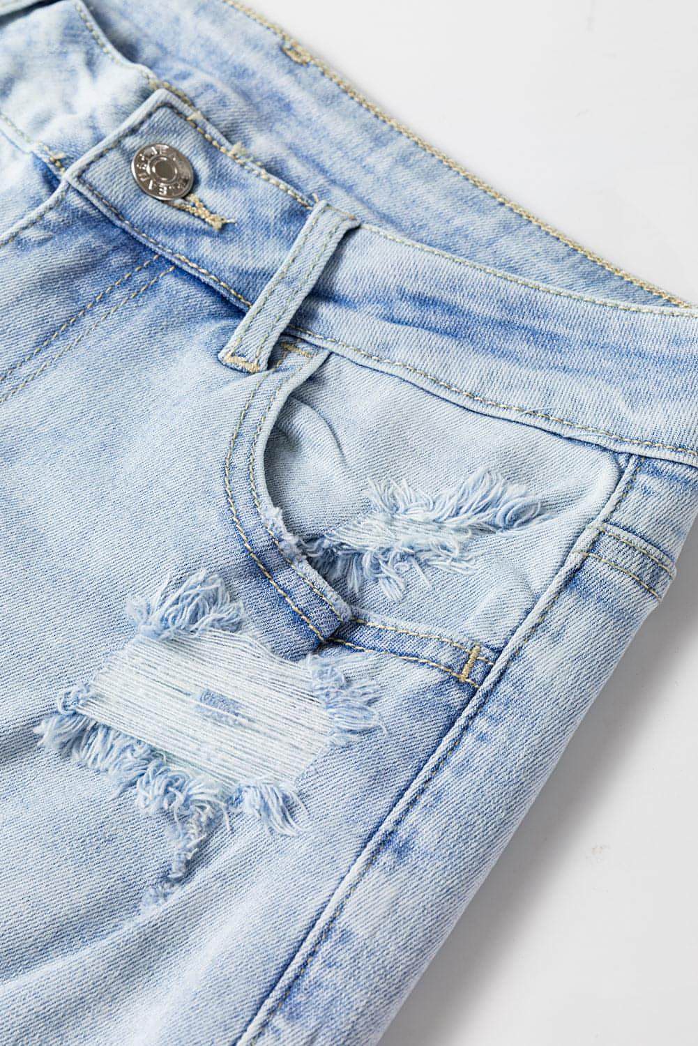 Carmine Juneberry Beau Blue vintage light wash distressed flare jeans with frayed edges and faded detailing.