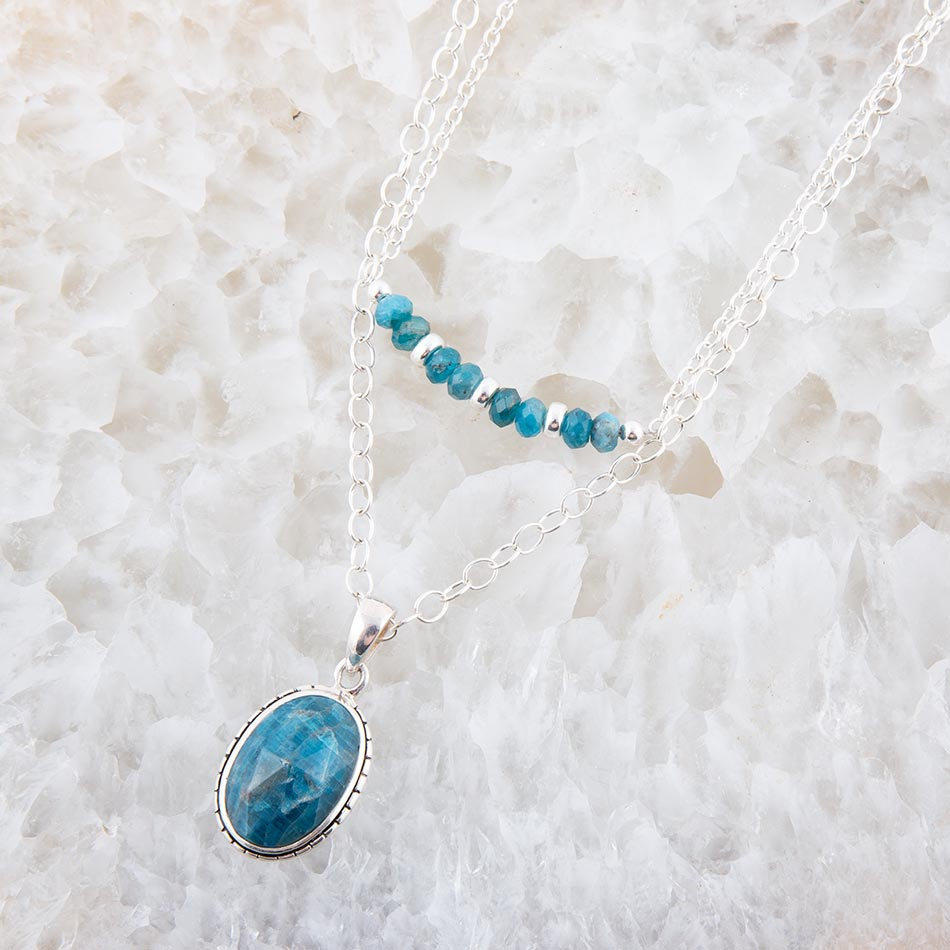 Layered blue apatite and sterling silver necklace with multiple blue gemstone pendants, elegant jewelry piece.