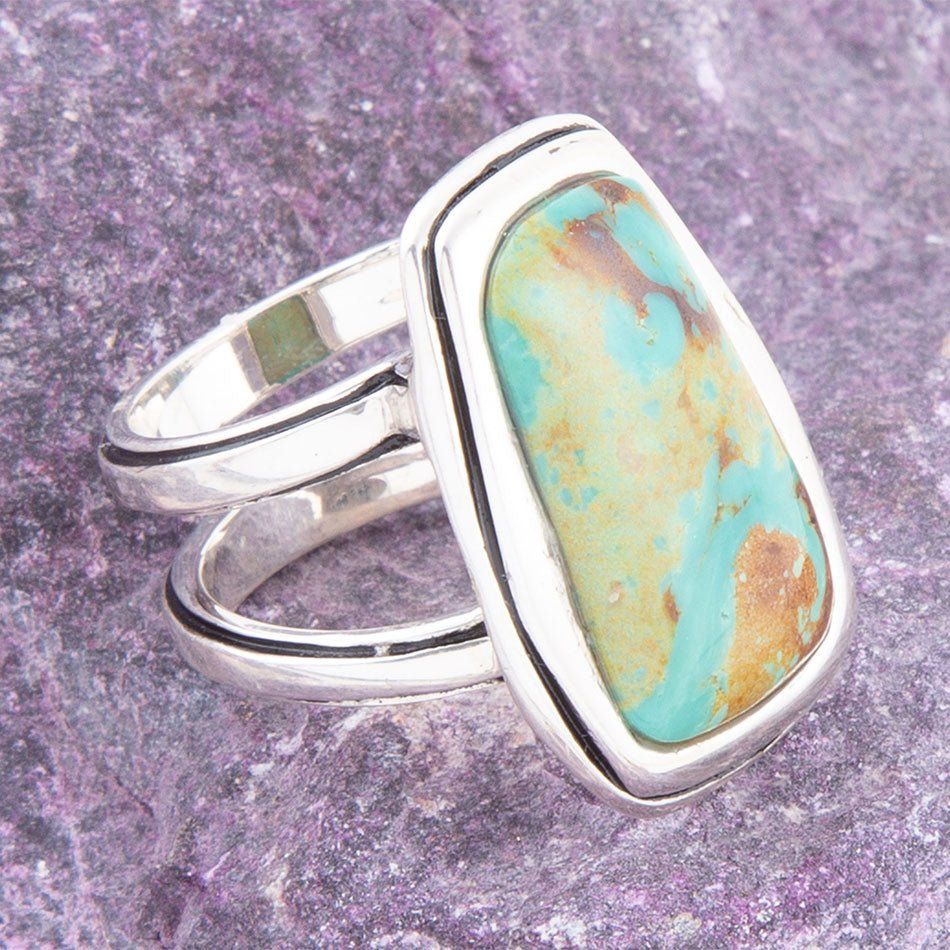 Blue turquoise and sterling silver statement ring with intricate jewelry design, showcasing bold craftsmanship and vibrant color.