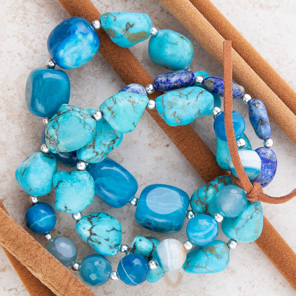 Sterling silver bracelet set with blue turquoise beads and silver accents, featuring multiple layered jewelry pieces.