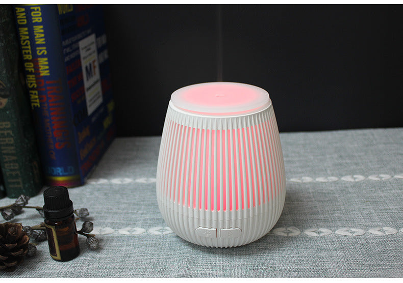 Colorful USB aromatherapy humidifier with fragrance lamp design, pink accents, and a compact, portable style for relaxing ambiance.