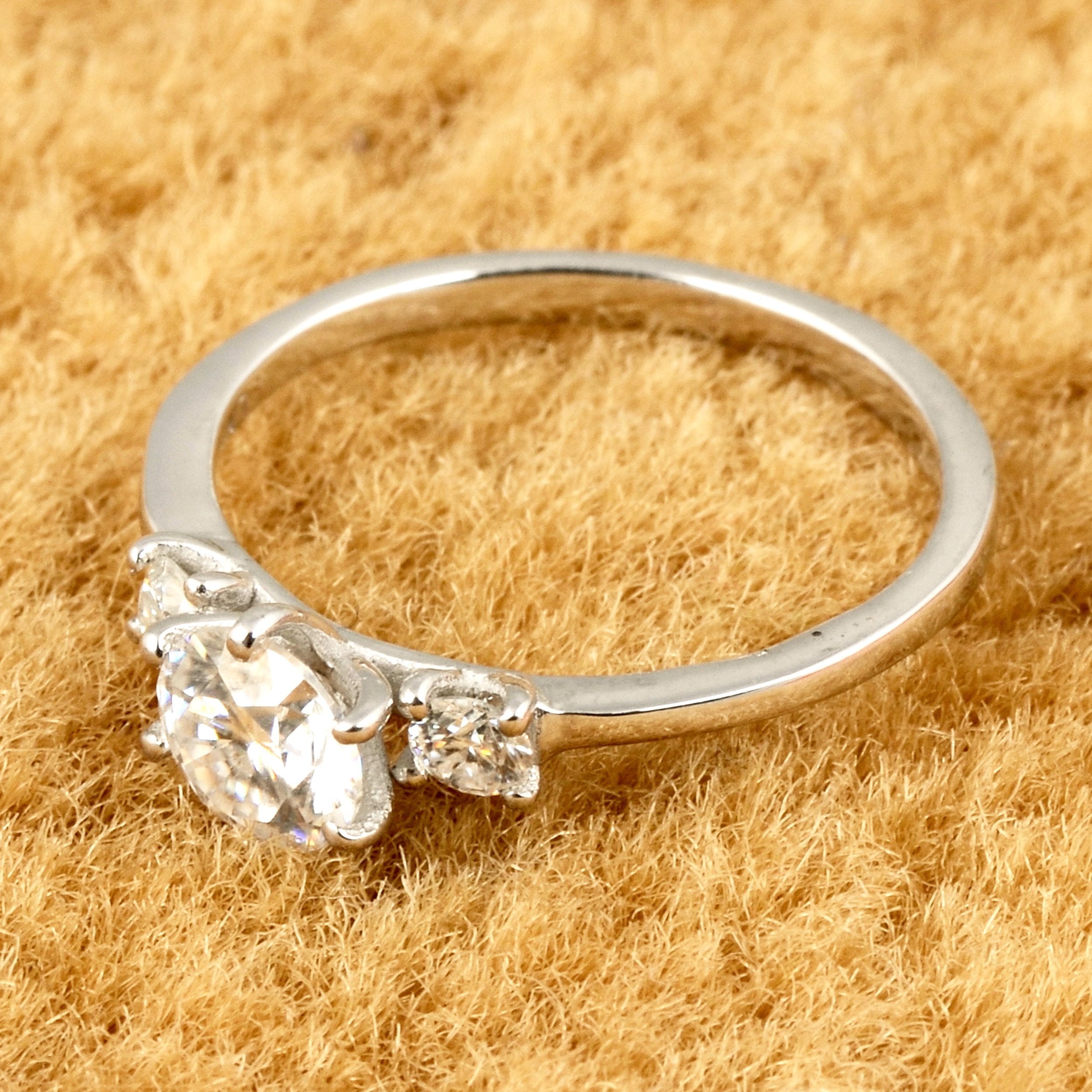 Sterling silver white moissanite 3-stone ring with elegant design, showcasing sparkling gemstones and smooth band detail.