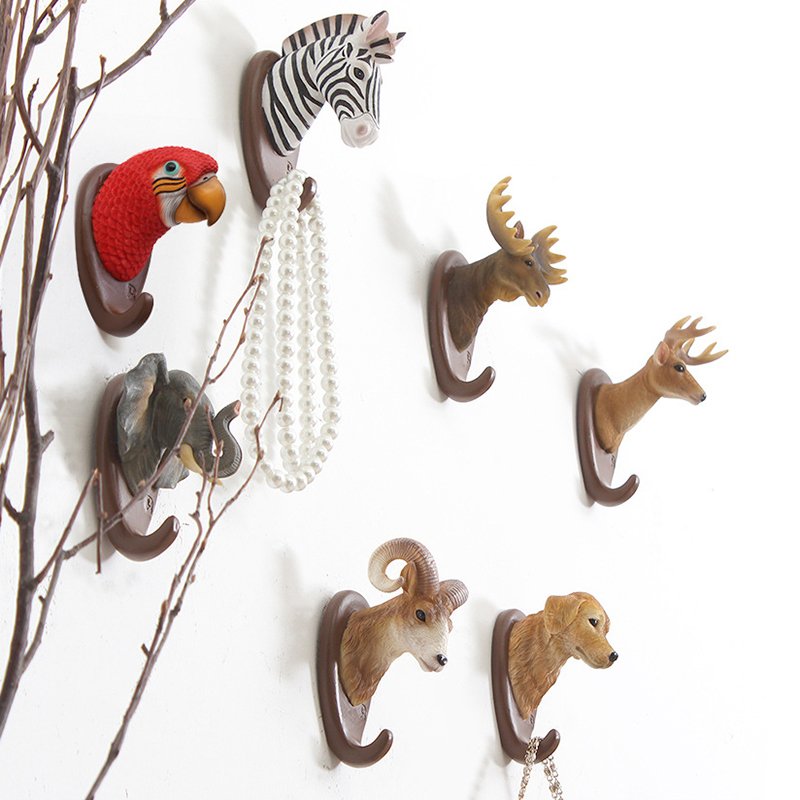 Fuchsia Molly animal wall hook mounted on a wooden wall, decorative home and garden accessory for hanging items.