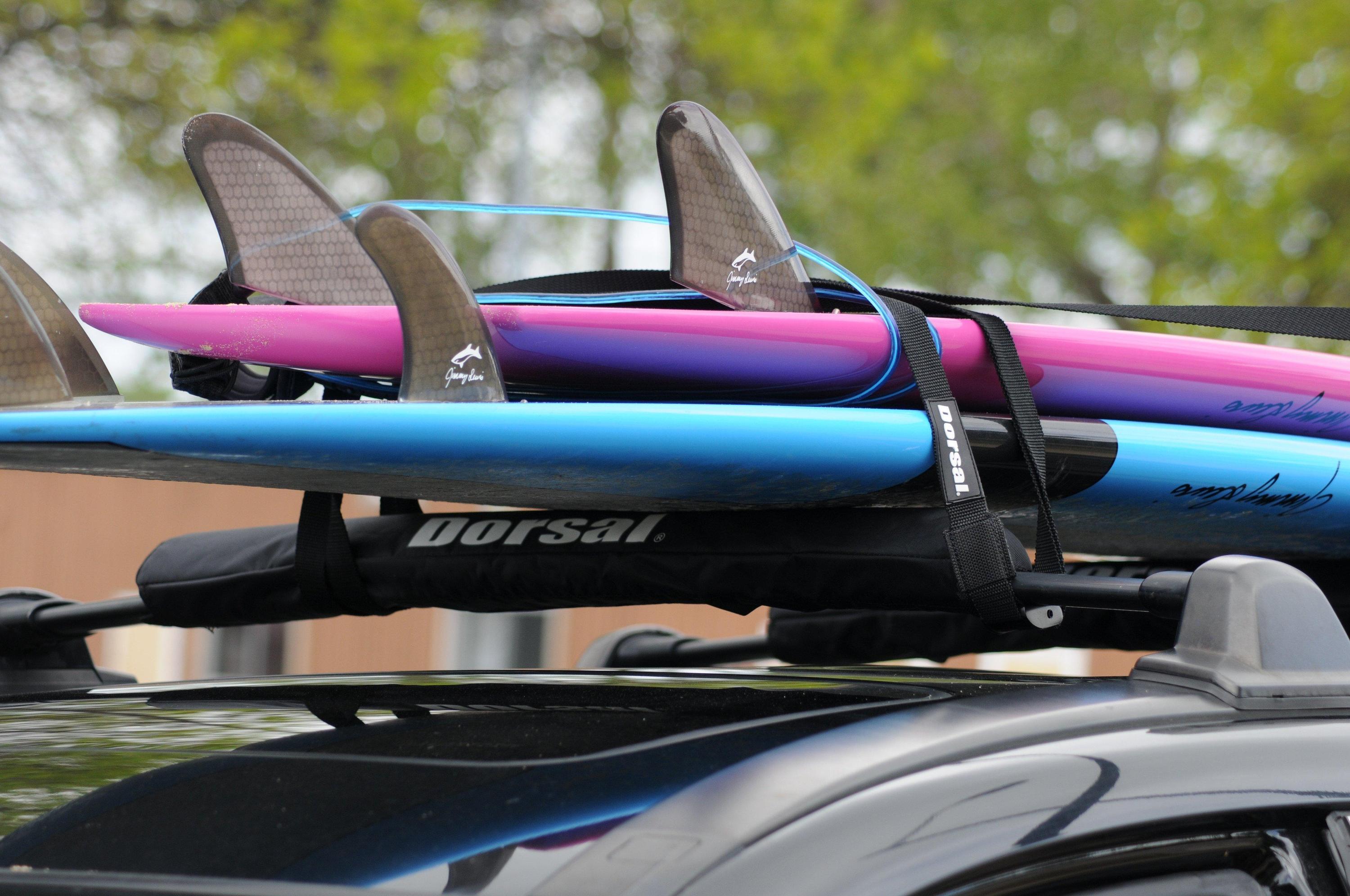 Cyan Hecuba DORSAL Aero Rack Pads on 34-inch car crossbars for roof rack, holding surfboards, kayaks, and SUPs.