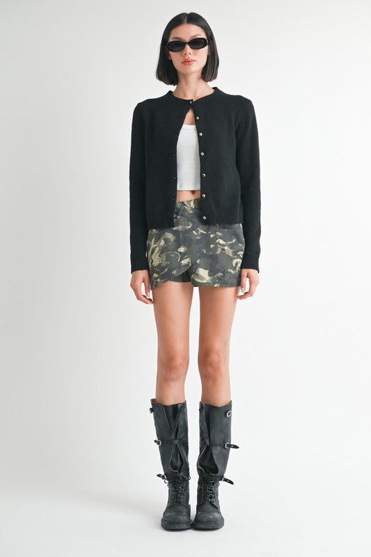 Automotive wrapped mini skirt with button detail by Jade Icarus, featuring a sleek, stylish design with button accents.