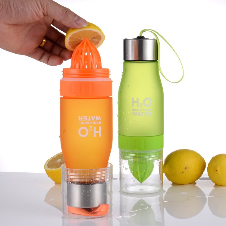 Fuchsia Molly lemon fruit juicer bottle in a kitchen setting showing the bottle with lemon juice and lemon slices inside.