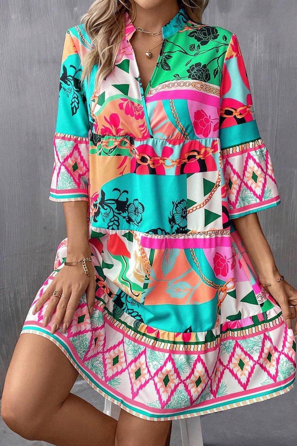 Multicolour abstract printed mini dress with notched neckline and half sleeves by Carmine Juneberry, displayed on a hanger.