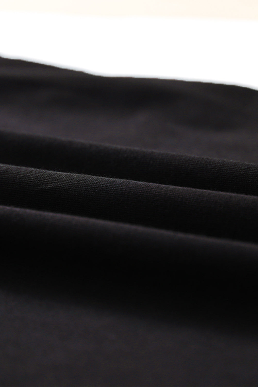 Black strappy hollow-out neck tank top from Harlequin Daisy, showcasing its stylish design and lightweight fabric.