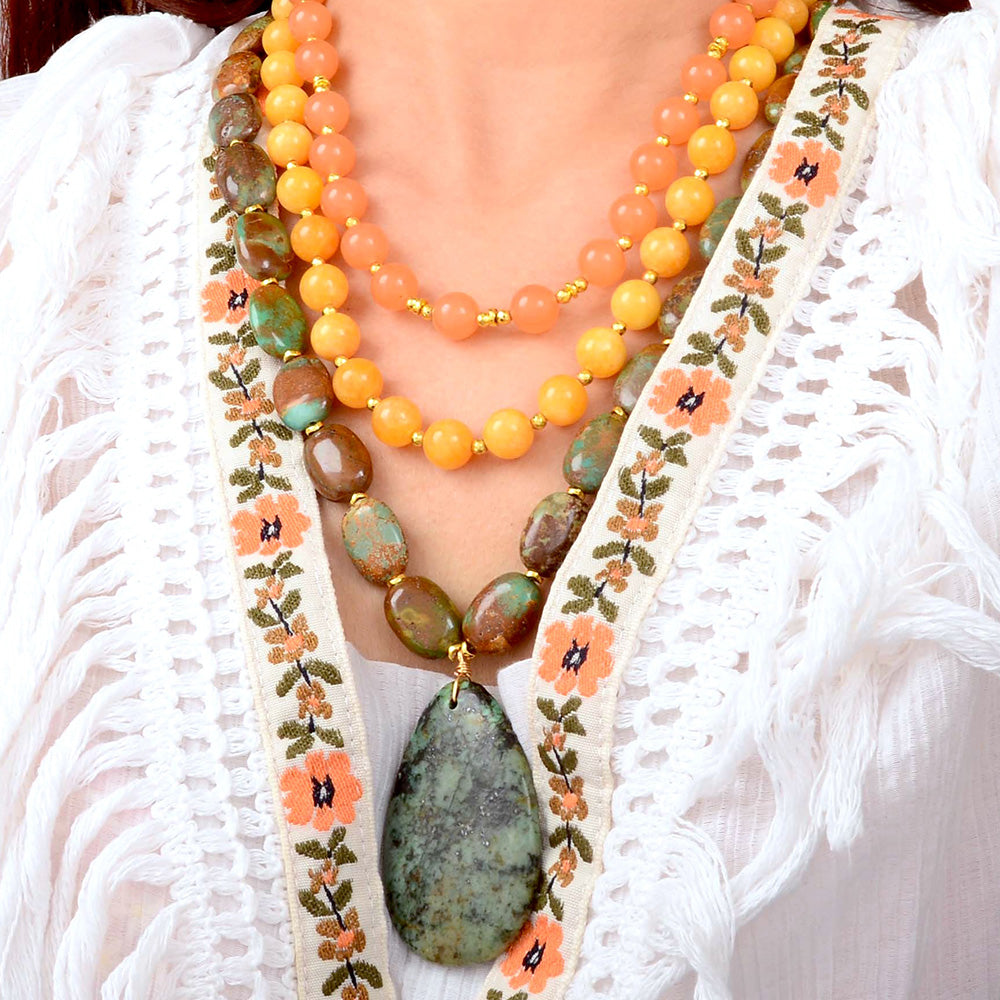 Green Chrysocolla pendant on a gold necklace, showcasing a vibrant, polished jewelry piece with natural stone detail.