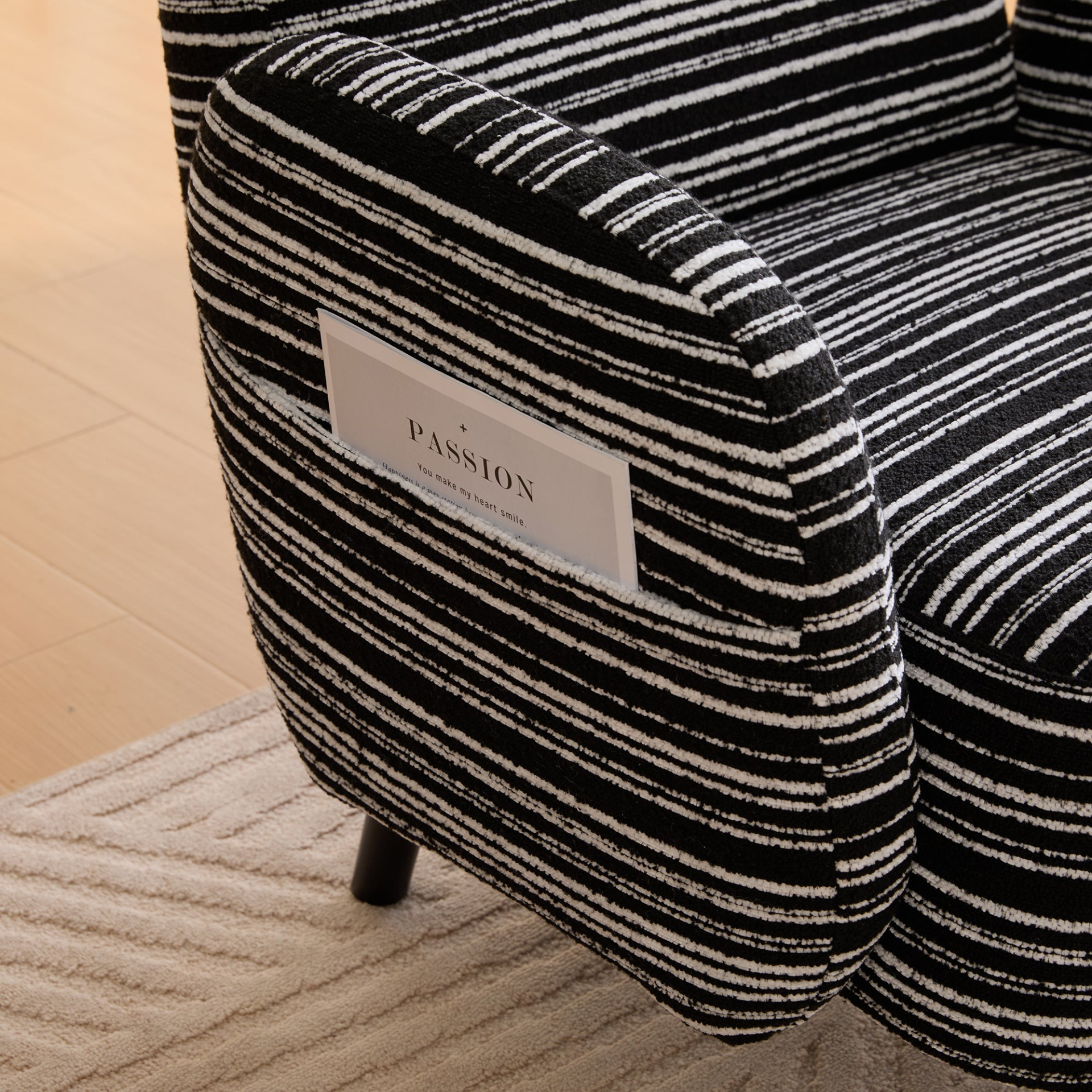 Modern armchair by Start2Finish with sanded fabric, solid wood legs, and a side storage pocket for stylish relaxation.