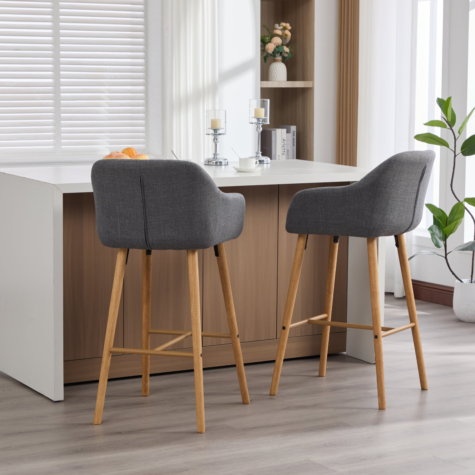 Modern linen upholstered bar stool with back, armrests, footrest, and solid wood legs, designed for stylish kitchen or bar area.