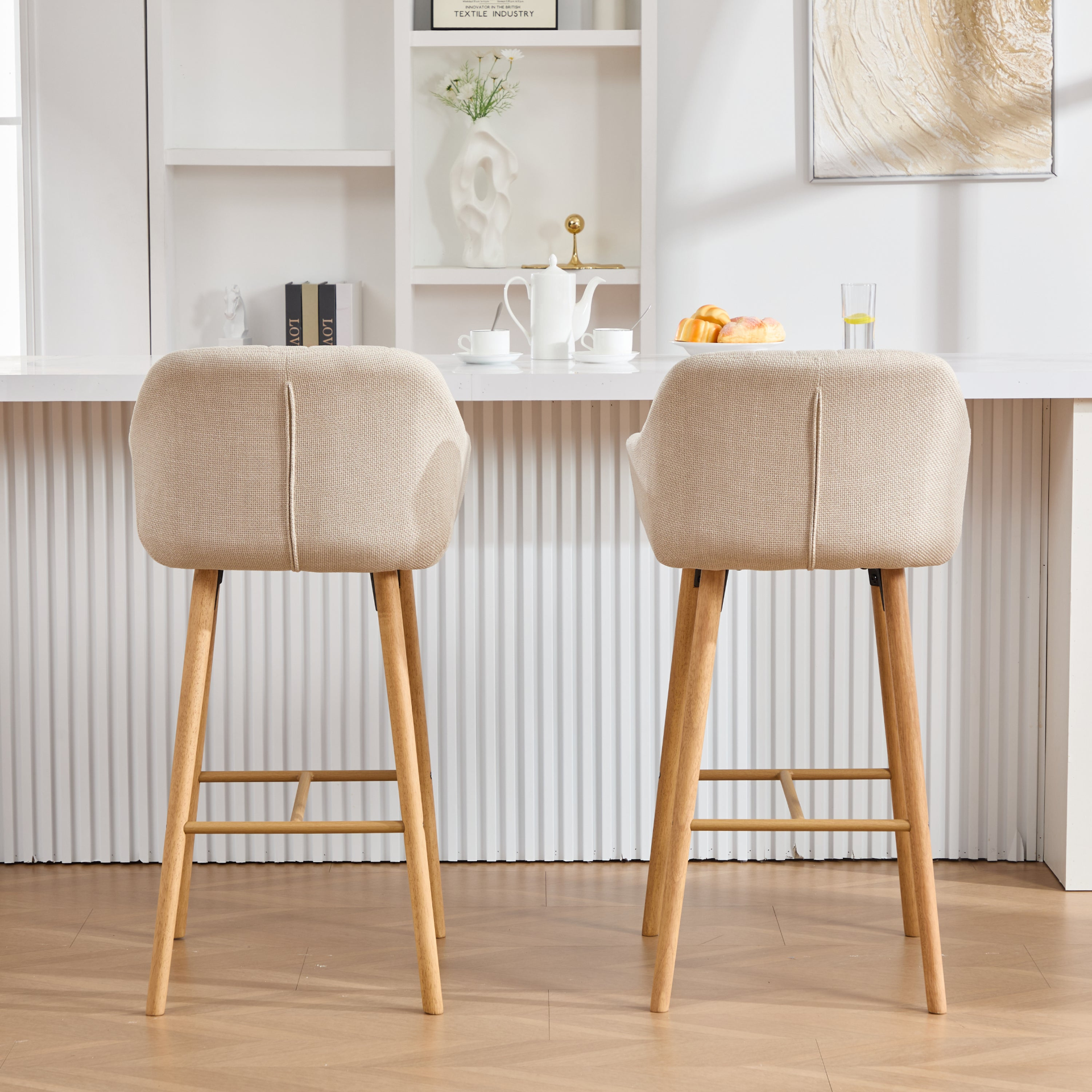 Modern linen upholstered bar stool with back, armrests, footrest, and solid wood legs, designed for stylish kitchen or bar area.