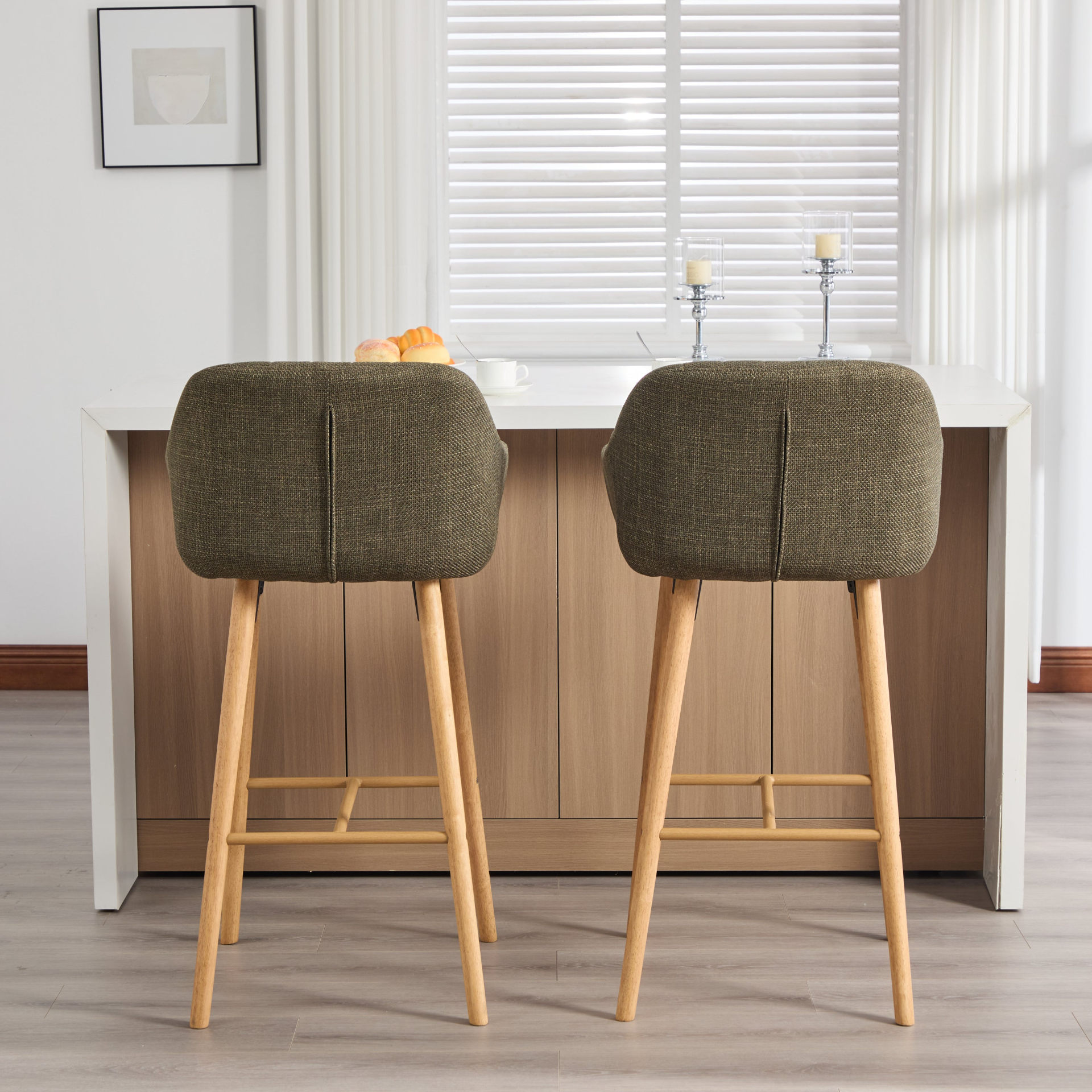 Modern linen upholstered bar stool with backrest, armrests, footrest, and solid wood legs, designed for stylish kitchen or bar seating.