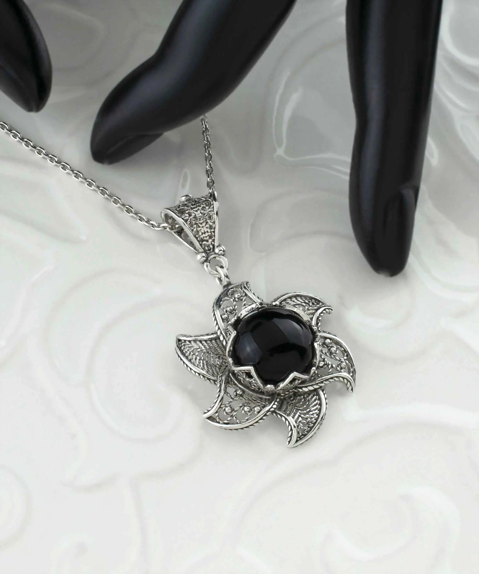 Sterling silver filigree lotus flower pendant with black onyx gemstone, intricate jewelry necklace with blossoming design.