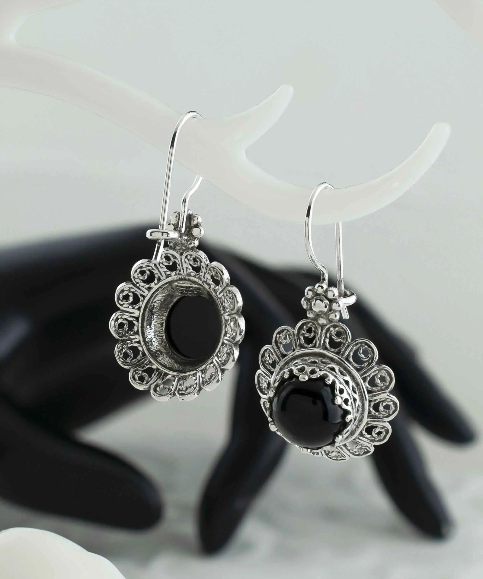 Silver drop earrings featuring black onyx gemstones with intricate filigree flower design for women.