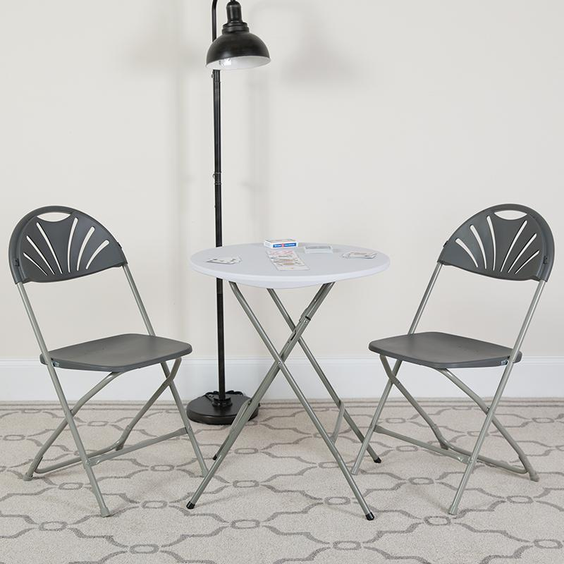 Two HERCULES Series charcoal plastic fan back folding chairs with 650 lb. capacity, lightweight and durable for versatile seating.