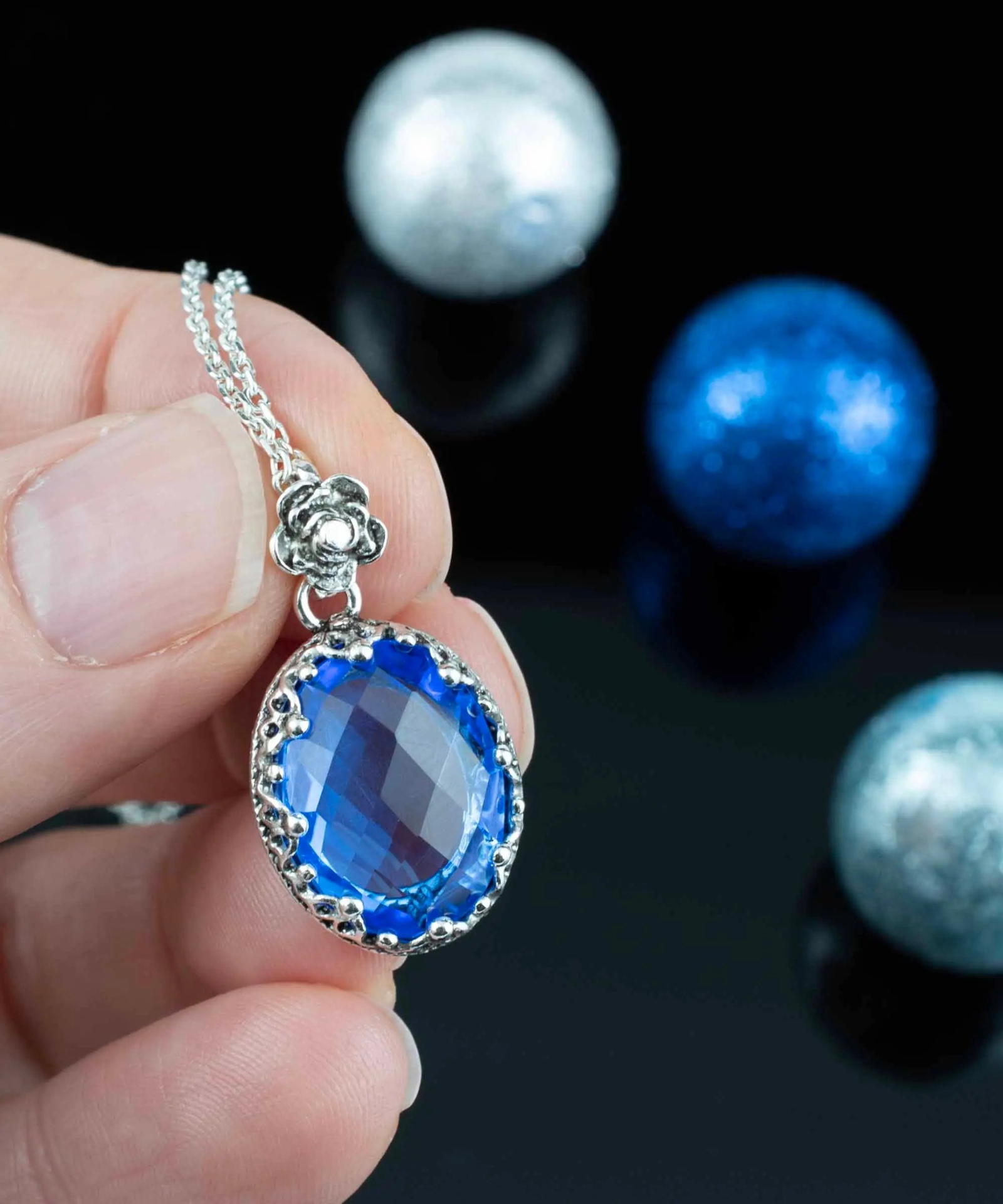 Silver filigree oval pendant necklace featuring a blue quartz gemstone, worn by a woman, from Start2Finish jewelry collection.
