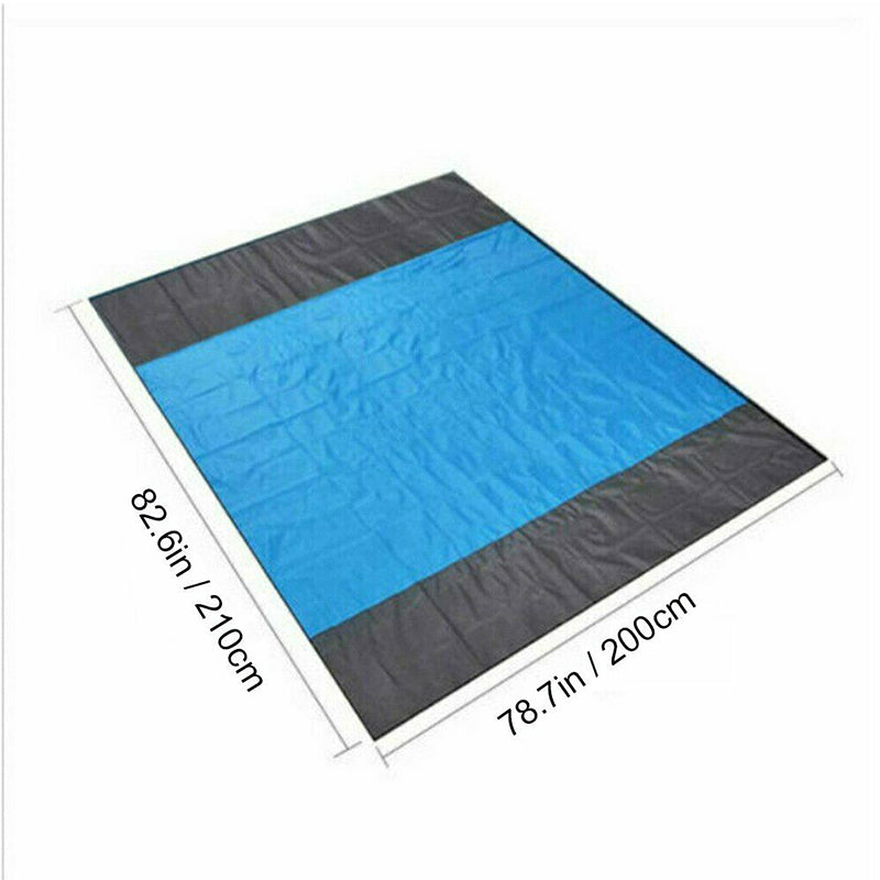 Maroon Asteria portable waterproof picnic and beach mat, lightweight camping blanket spread on a grassy area.