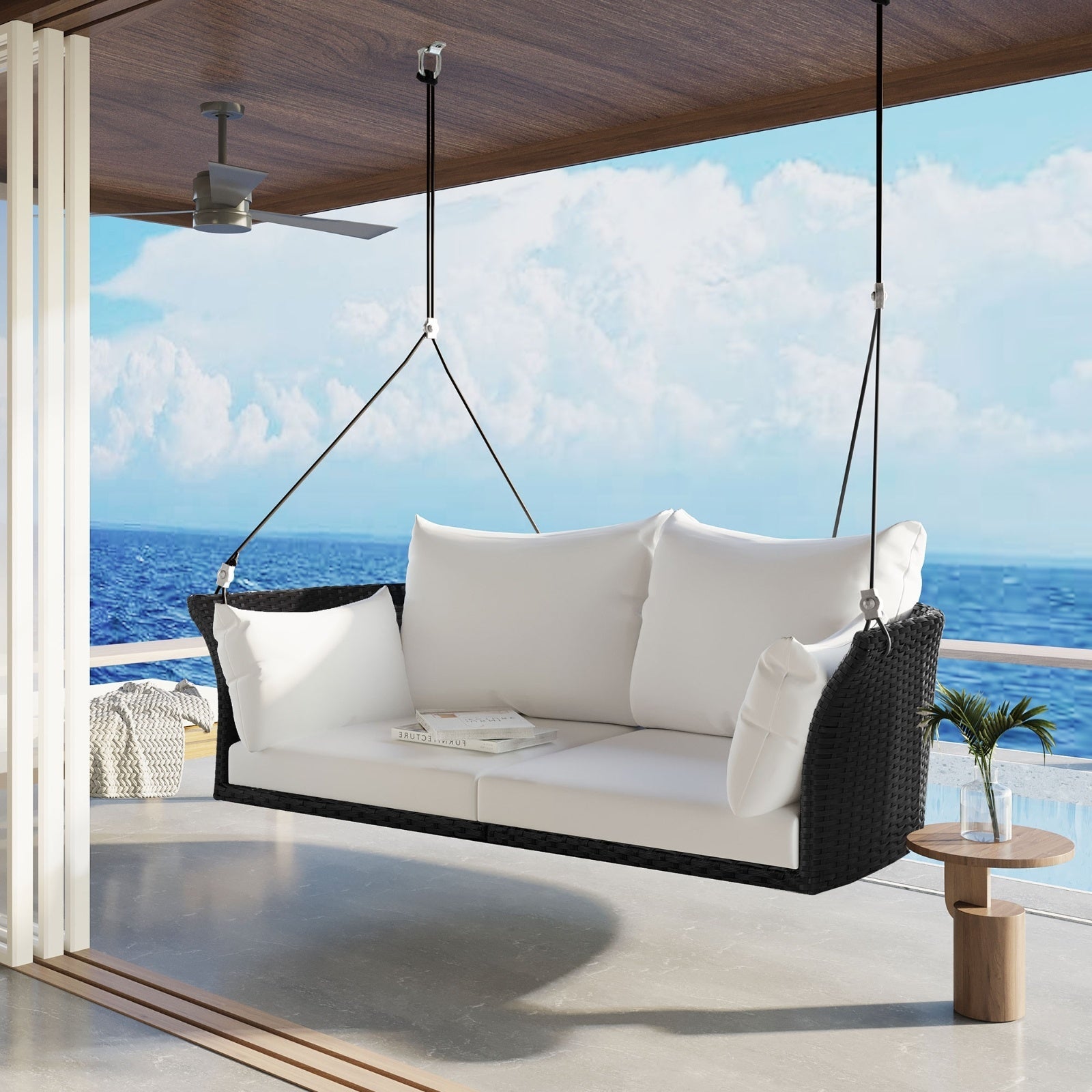 Black wicker hanging rattan porch swing for two from Carmine Juneberry, designed for garden outdoor relaxation.