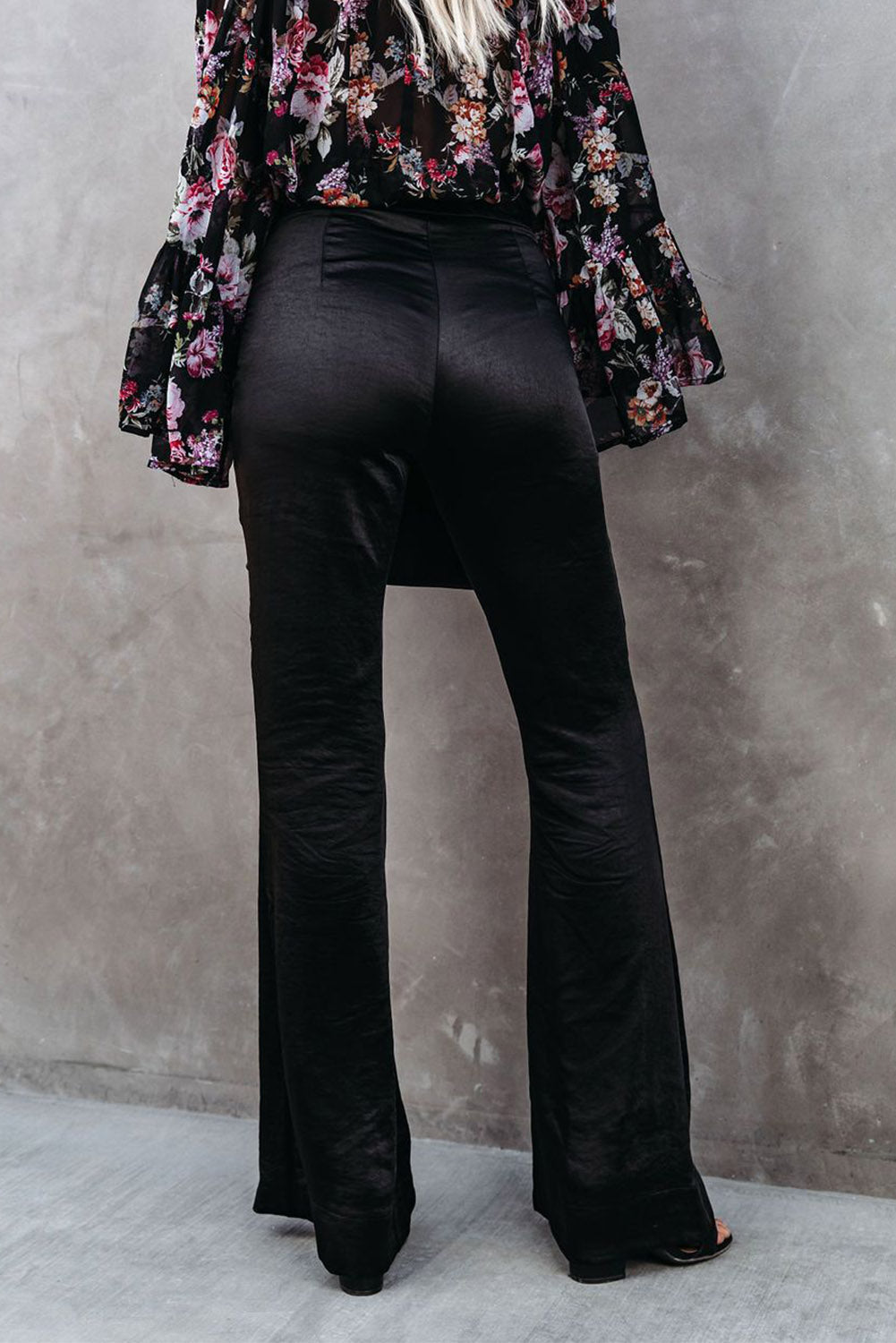 Black satin flare tailored pants by Harlequin Daisy, stylish and elegant bath and beauty clothing, shown on a model.