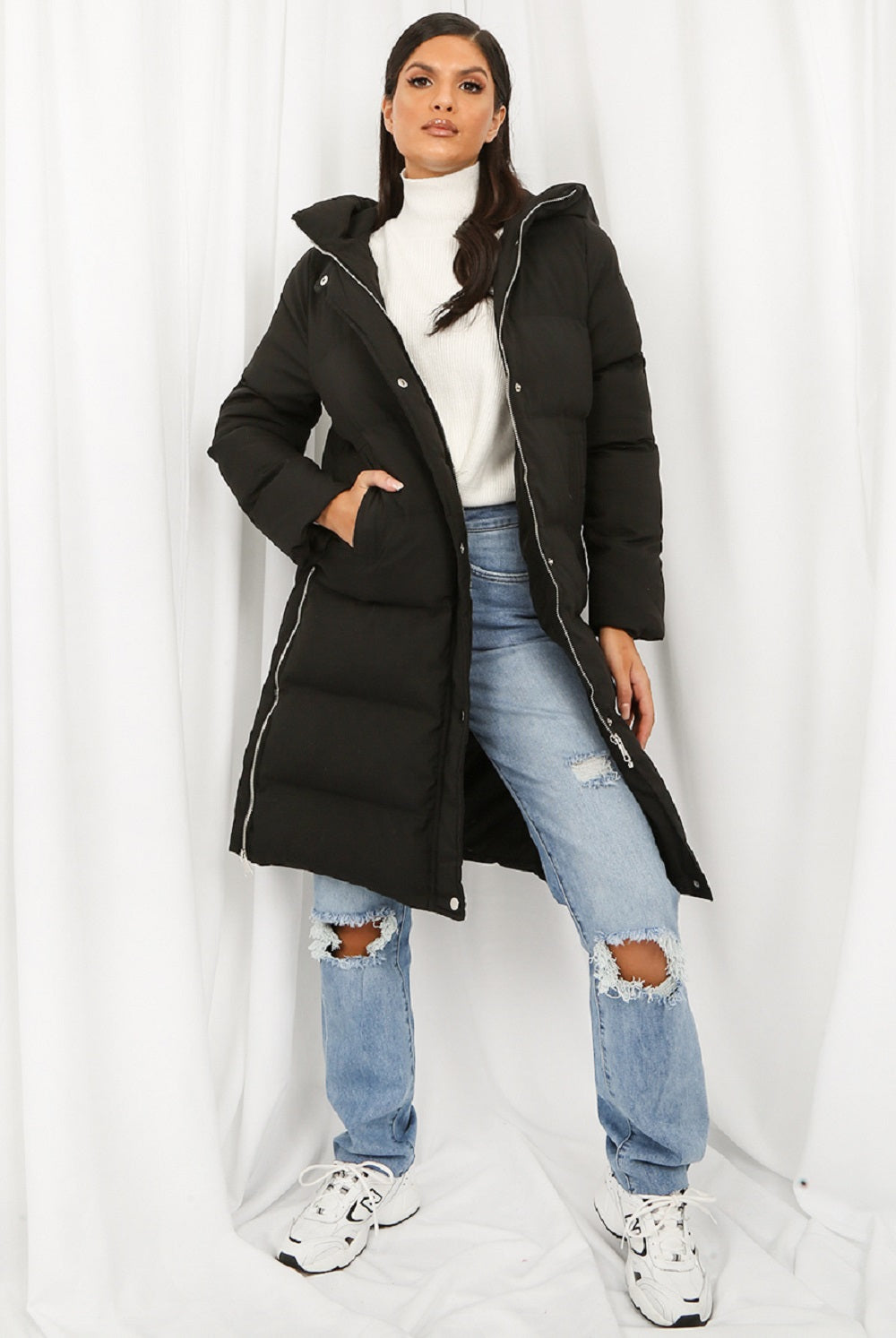 Black Rose Eleusis hooded longline puffer coat with a high collar, insulated for warmth, displayed on a hanger.