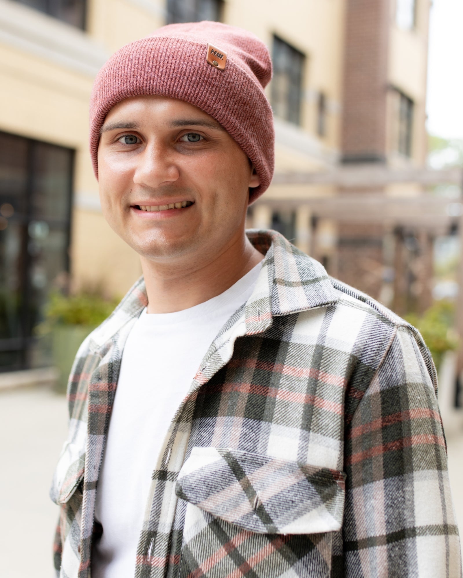 Azure Arrowwood HAAKWEAR knit cuffed beanie in rusty burgundy, showing its cozy knit texture and folded cuff detail.