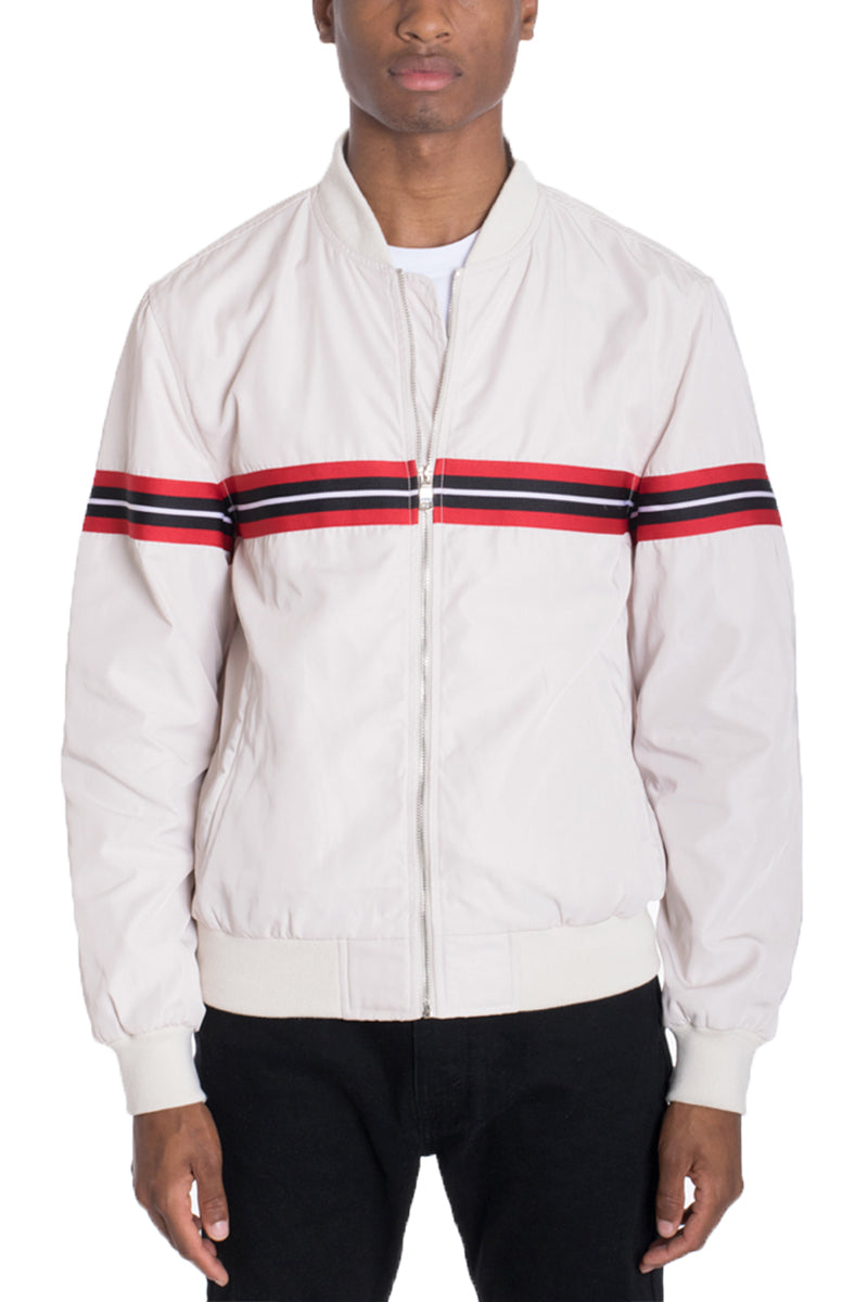 Beige Lime Milo Dom Taped Bomber jacket with black accents, front zipper, and ribbed cuffs, displayed on a hanger.