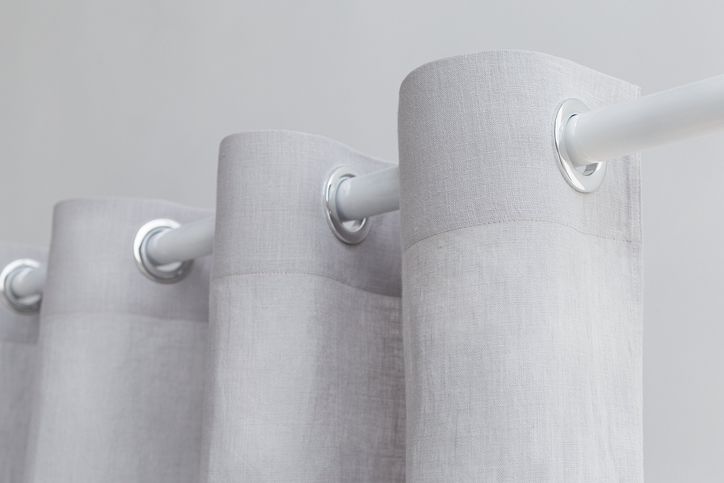 Light grey linen curtain with grommets, Magenta Sugarplum home decor, hanging on a window with natural light.