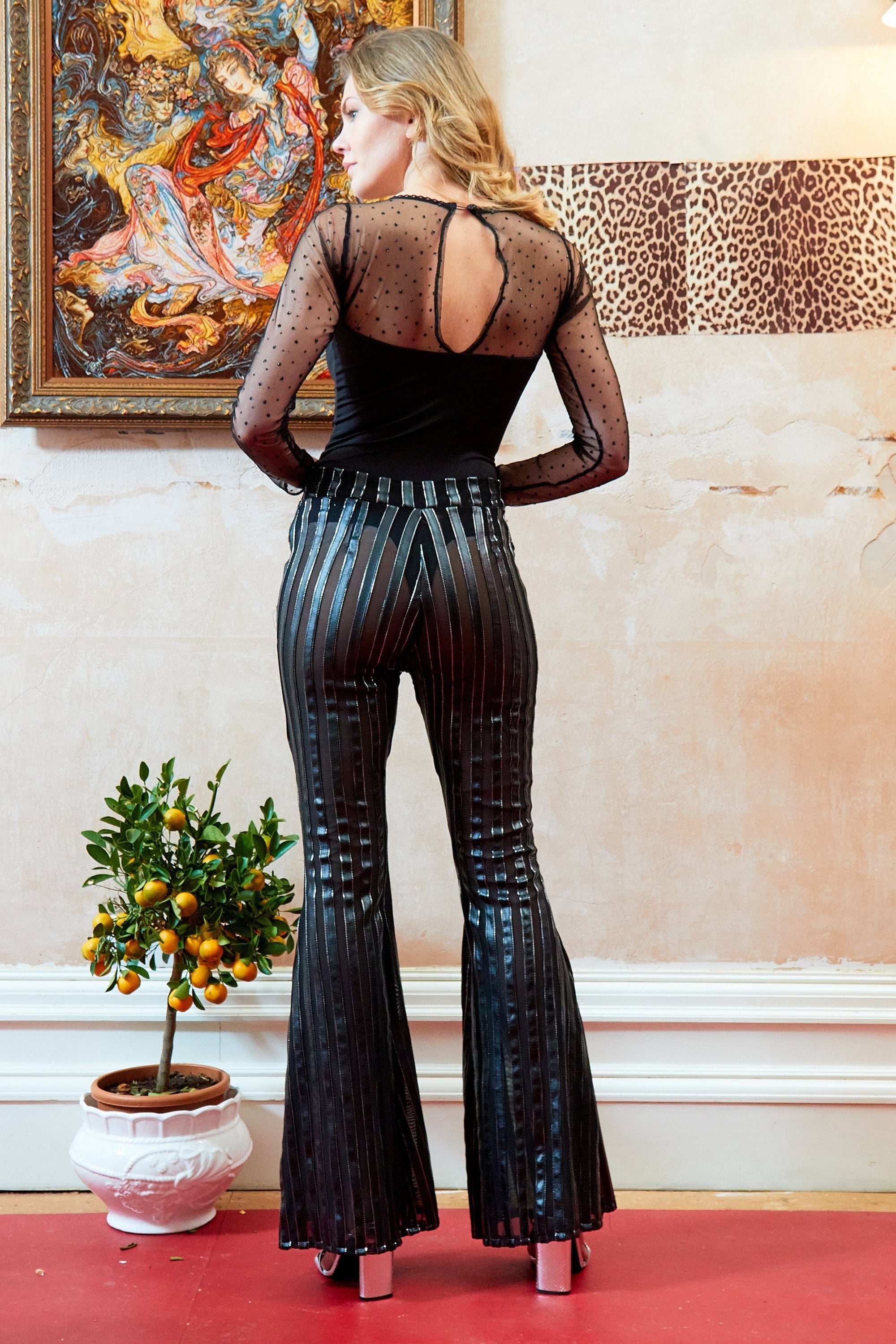 Long-sleeve mesh bodysuit from Blush Athena paired with Sly trousers, featuring sheer fabric and fitted style.