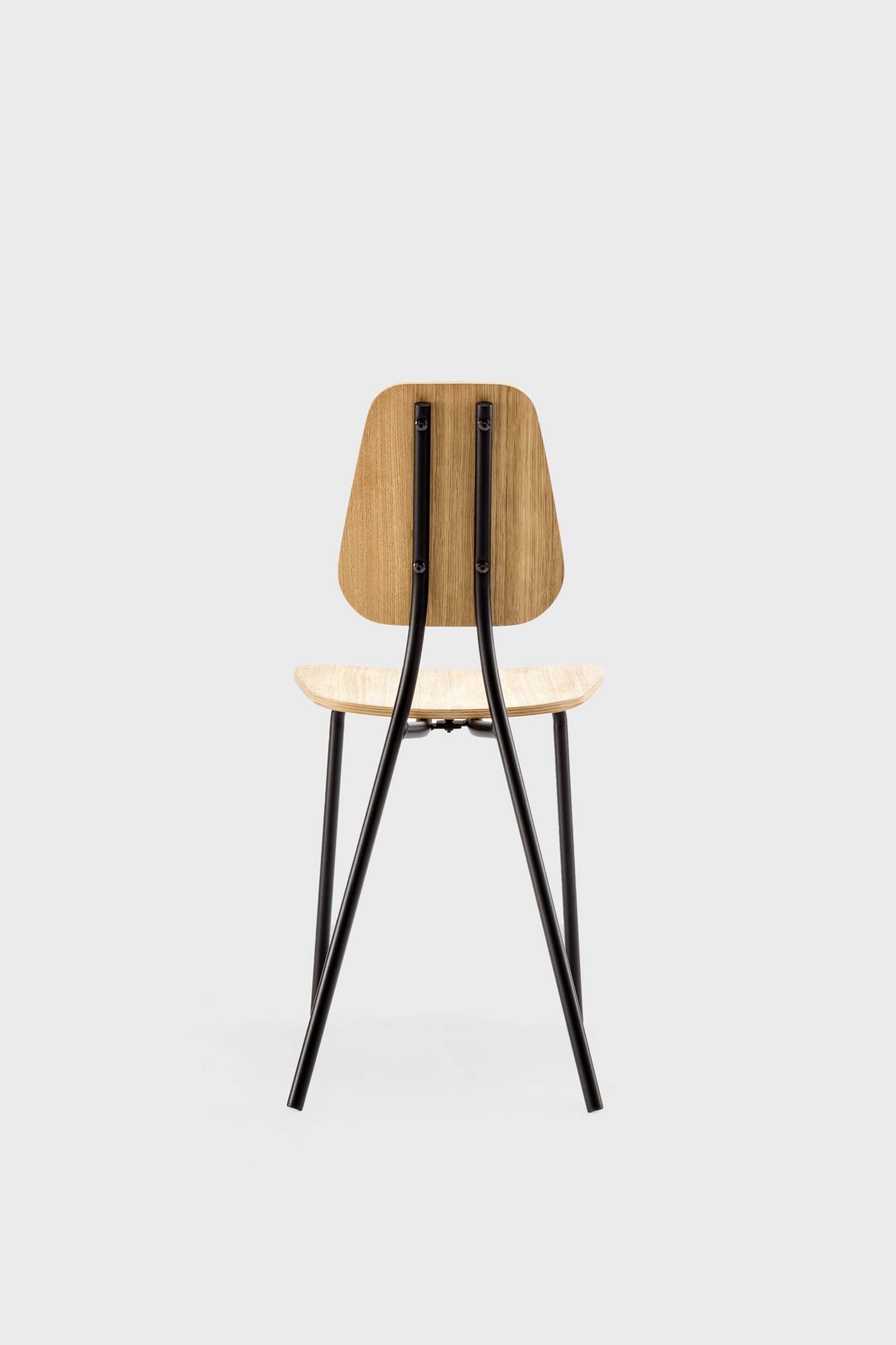 Aquamarine Poppy Hoya Chair in oak finish, modern furniture piece with a sleek design and wooden frame, photographed from a side view.