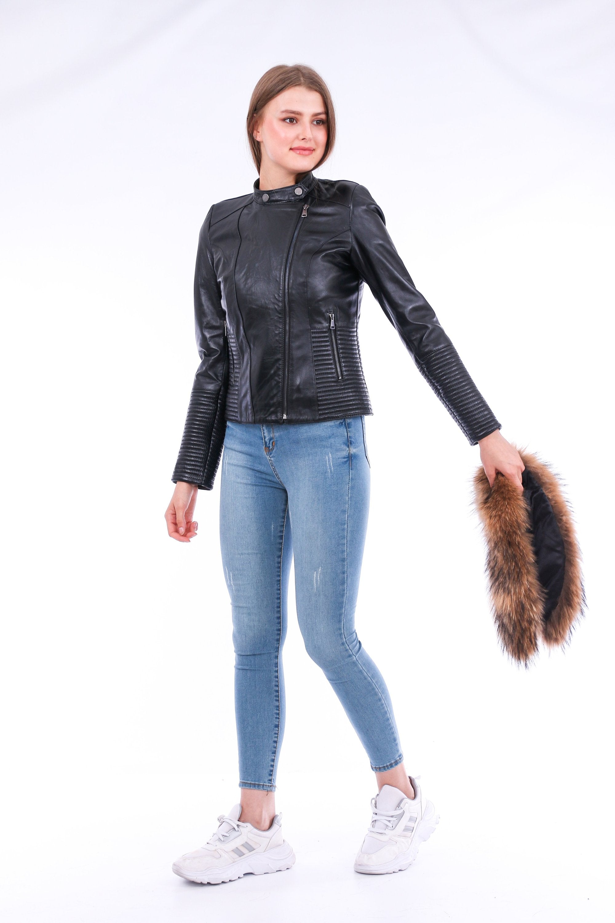 Black Ravenna leather biker jacket by Sangria Iapetus hanging on a wooden hanger. Features classic lapels and silver zipper details.