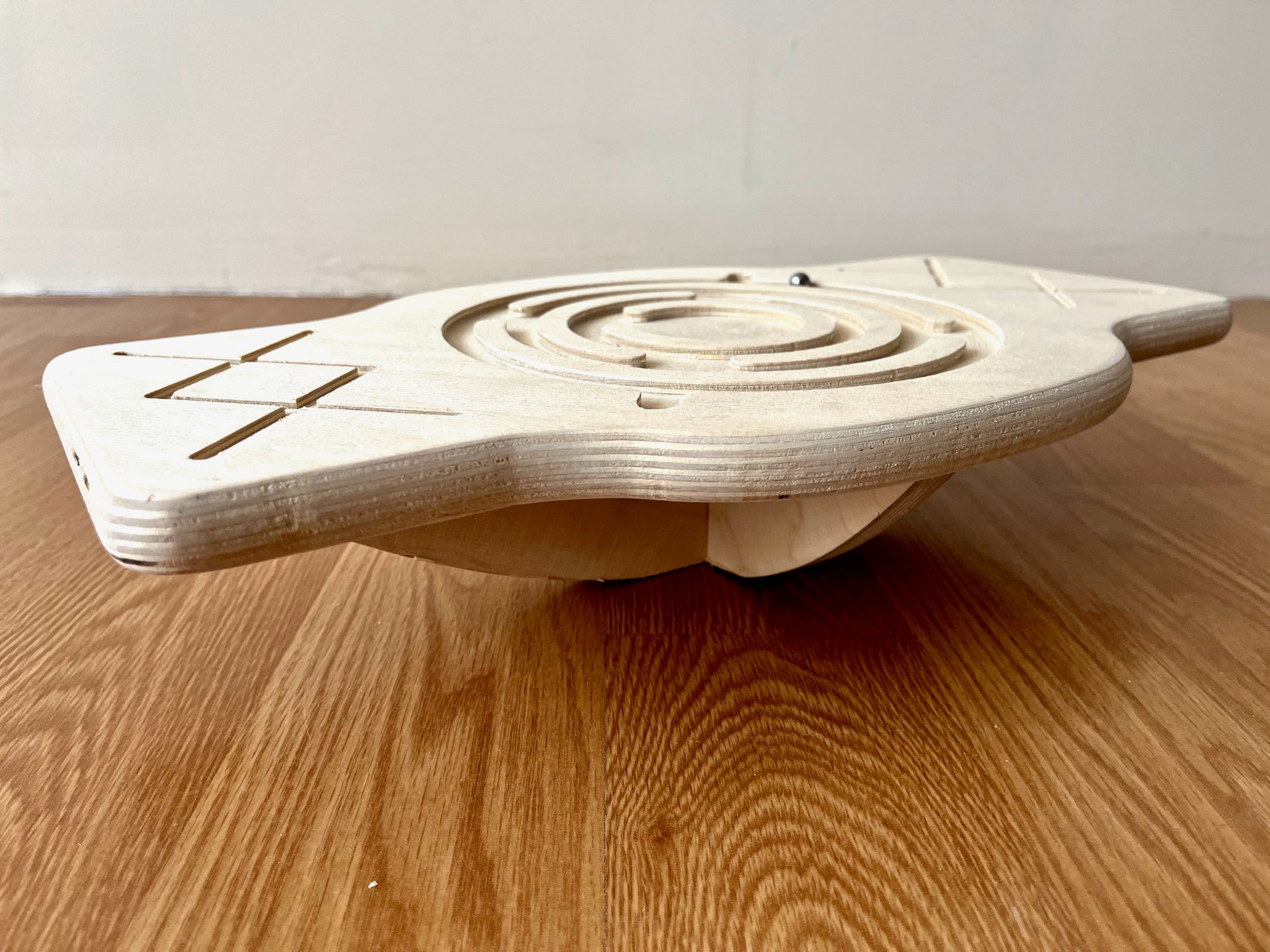 Red Oceanus Maze Wooden Balance Board, a natural wooden furniture piece with a maze design, suitable for play and decor.