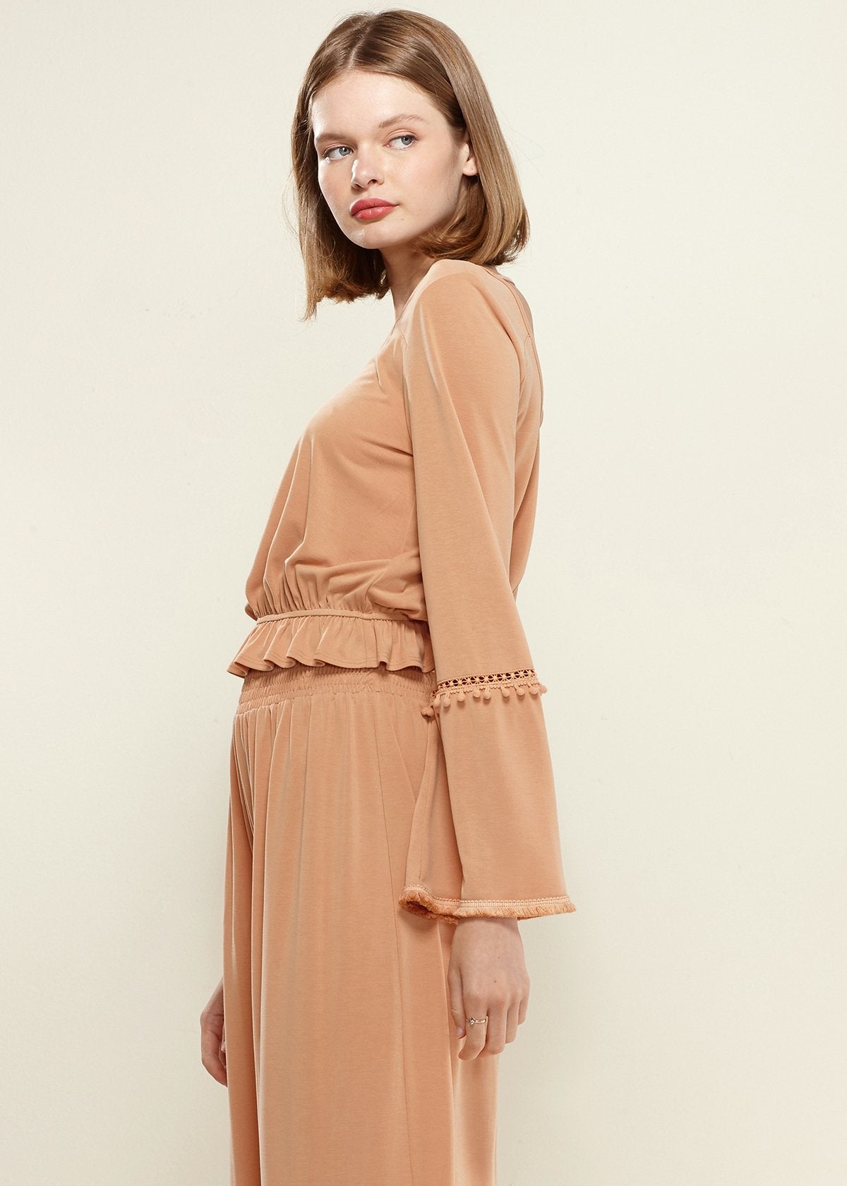 Women’s apricot fringe cuff bell sleeve top by Lemon Hera, featuring stylish bell sleeves and textured fringe details.
