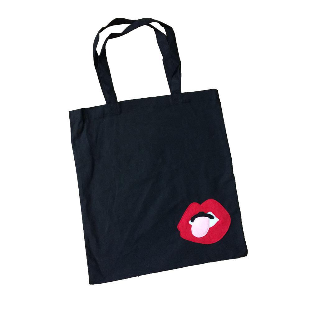 Black tote bag featuring a Lips design by Donald Robertson, part of the mi cielo x Donald Robertson collection, by Sky Blue Milo.
