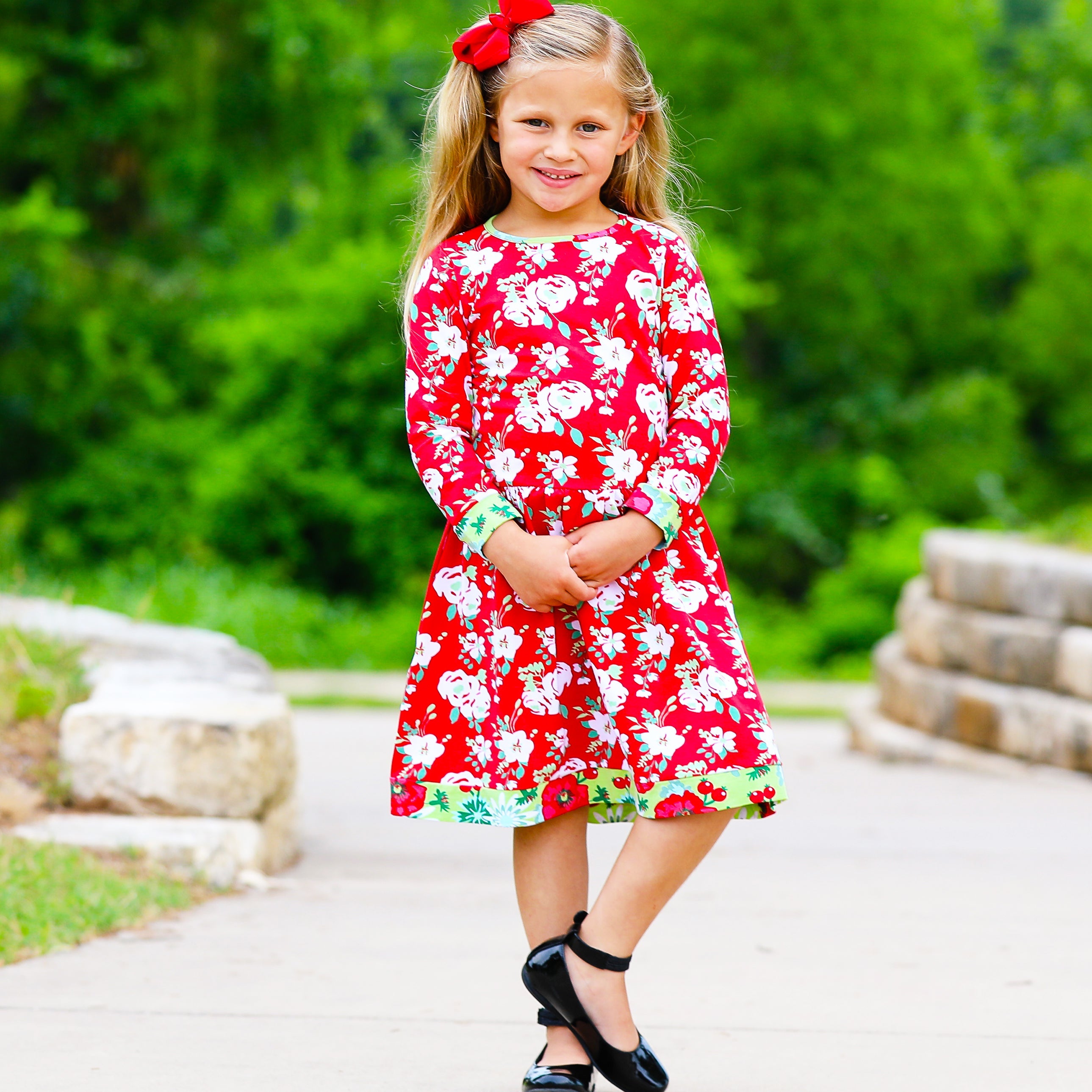 Black Simba AnnLoren girls Christmas floral long sleeve cotton party dress modeled by a young girl.