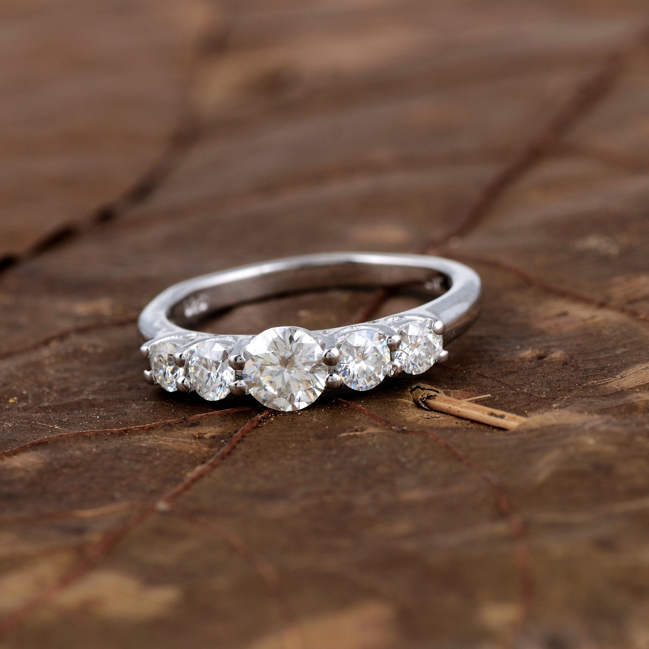 Sterling silver white moissanite 5-stone ring featuring sparkling gemstones, elegant jewelry piece from Copper Juniper.