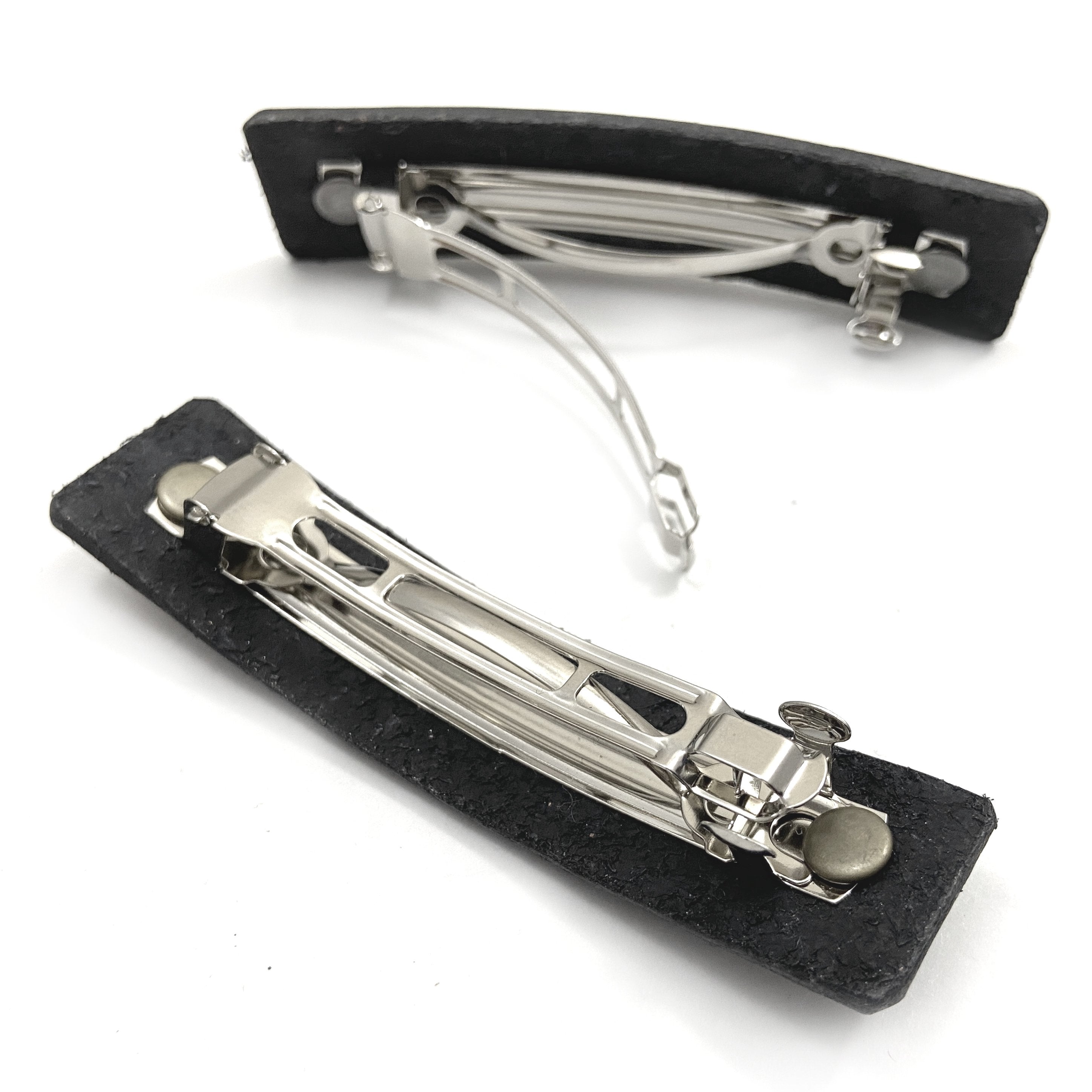 Silver feather hair barrette with black leather backing from Orange Themis, perfect for stylish hair accessories.