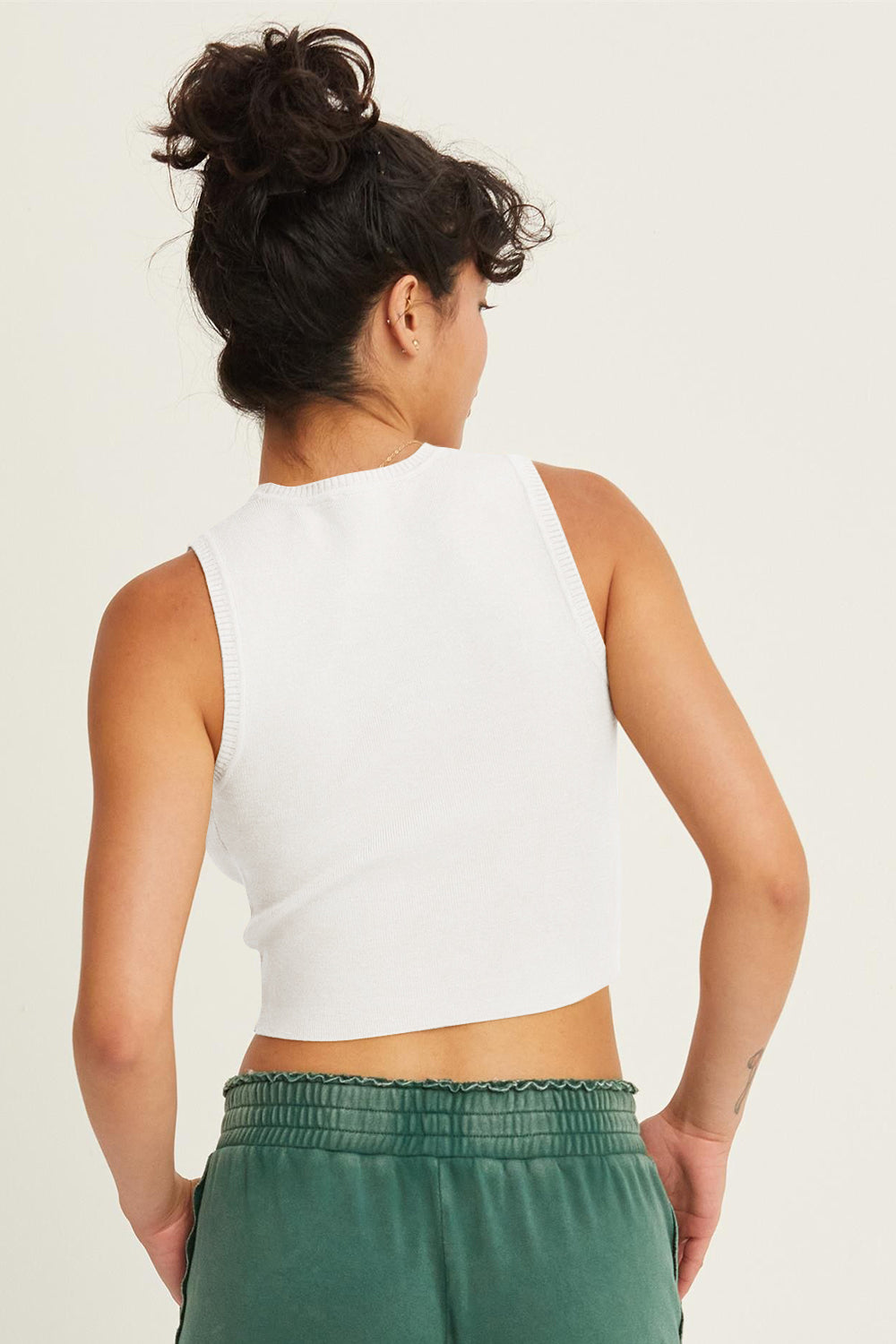 Ribbed knit cropped tank top by Jade Icarus, featuring a fitted style with textured fabric and a cropped length.