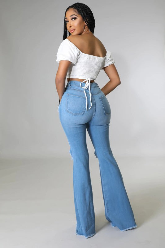 Medium wash Jade Icarus knee rip flare jeans with 32-inch inseam, showing distressed details and stylish fit.