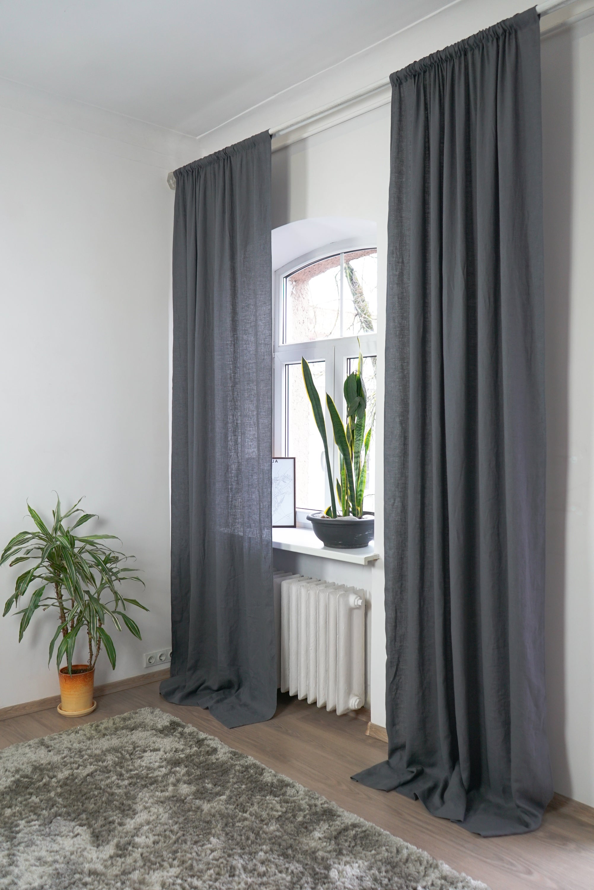 Grey linen curtain with rod pocket by Magenta Sugarplum hanging on a window, showcasing elegant home decor.