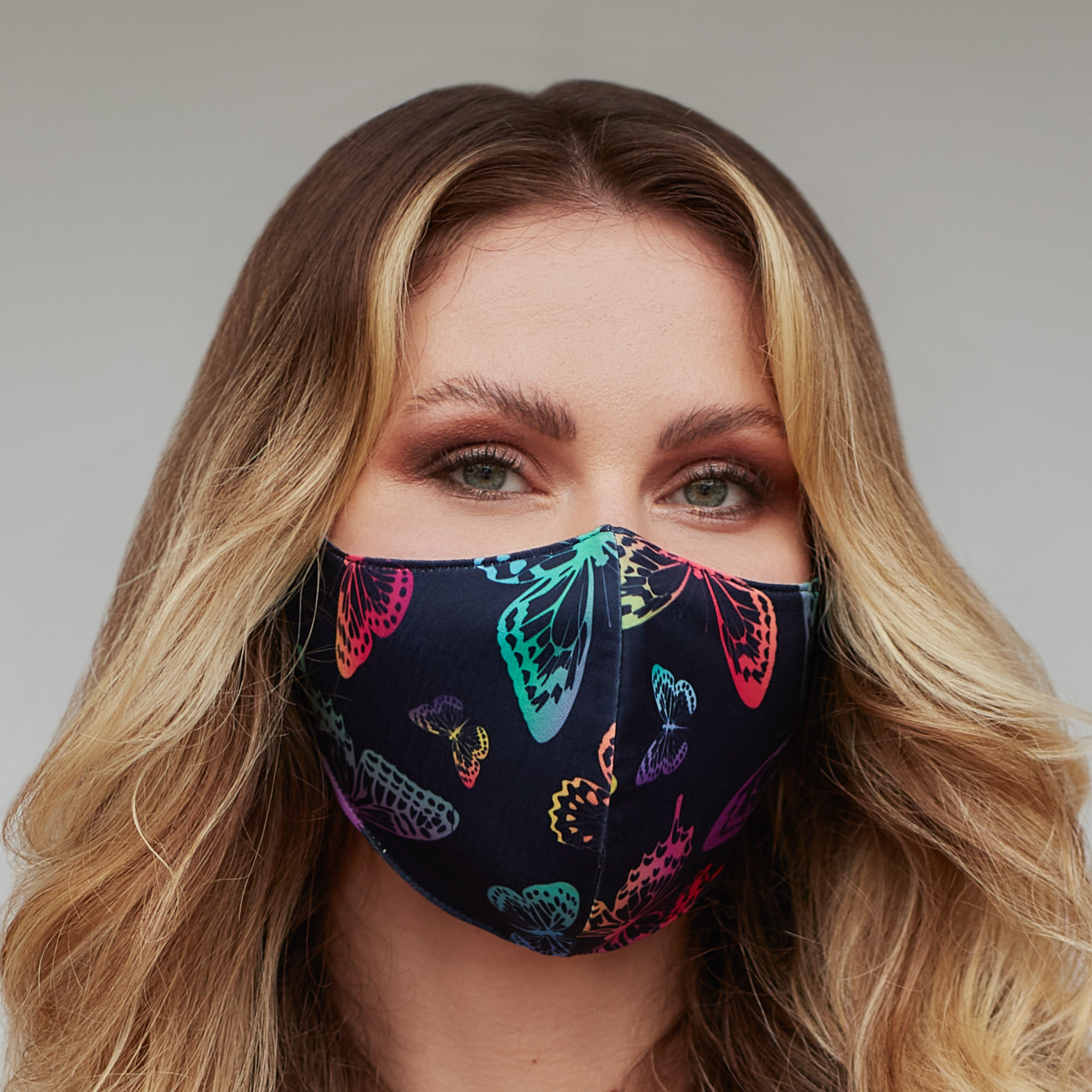 Neon butterfly face mask for women by Cyan Poppy featuring vibrant butterfly designs on colorful fabric.