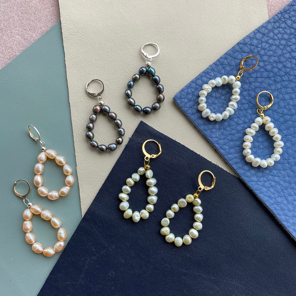 Yellow Athena pearl drop earrings featuring elegant white pearl pendants hanging from gold-tone earrings.