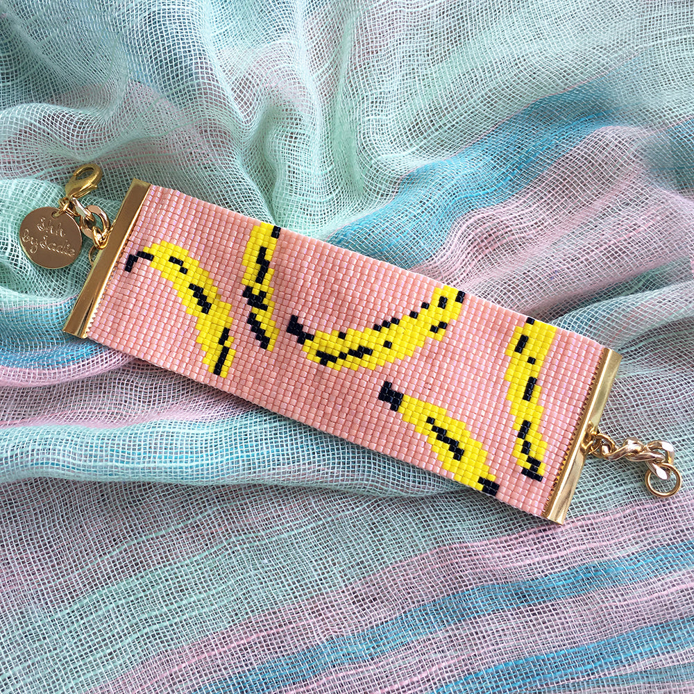 Yellow Athena Bananas Bracelet in peach color, stylish jewelry accessory featuring banana-shaped charms on a delicate bracelet.