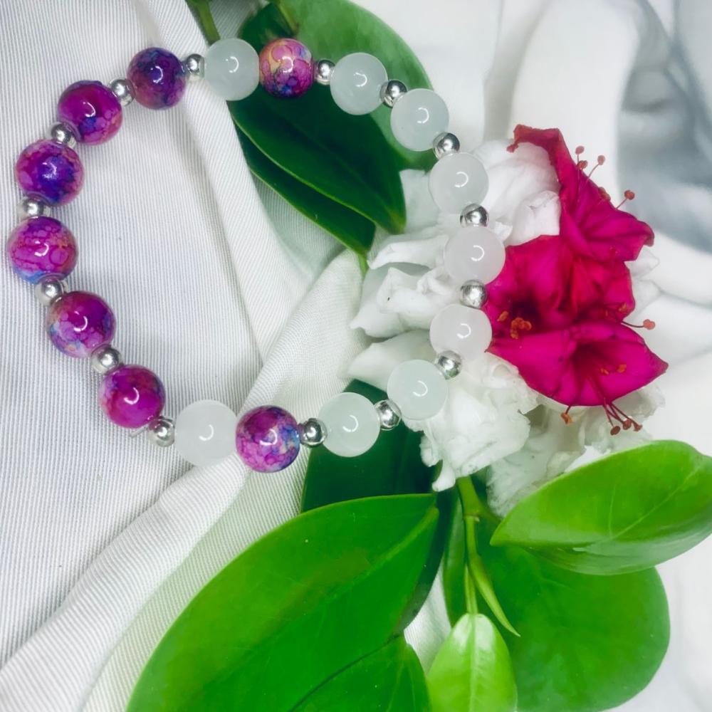 White and purple stone stretch bracelet with silver spacers by Tan Saffron, featuring smooth oval gemstones on a flexible band.