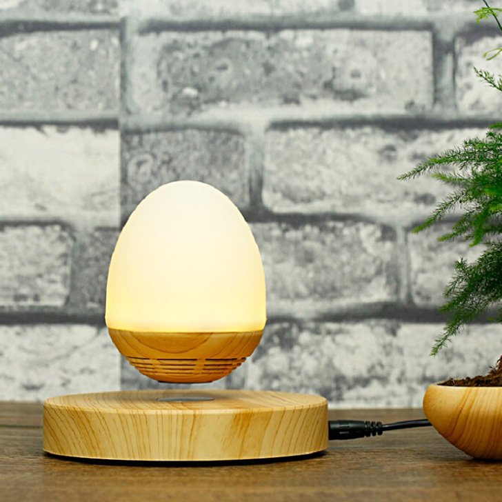 Fuchsia Molly Bluetooth magnetic levitation speaker floating above a sleek surface in a modern home setting.