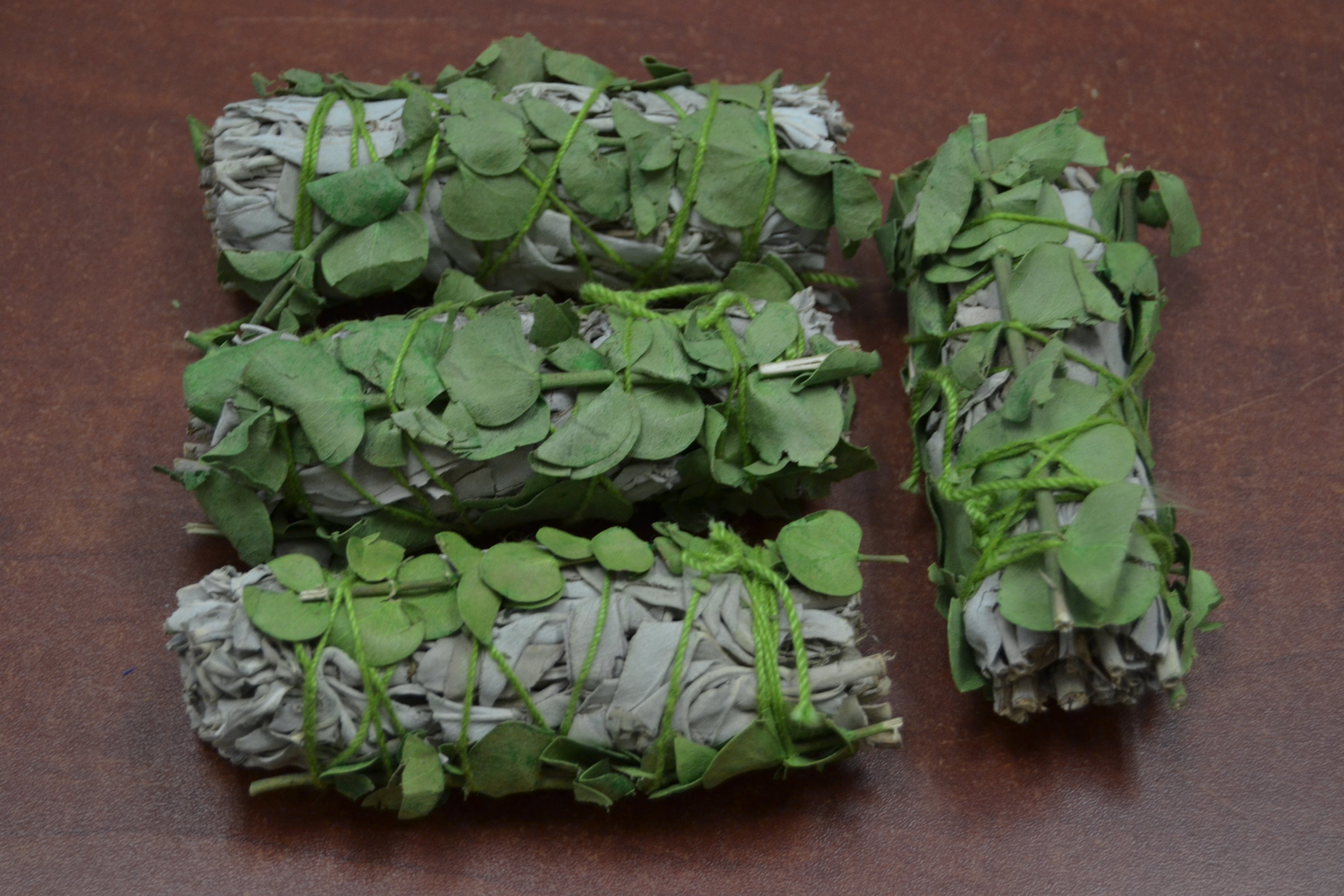 Four white sage and eucalyptus bundle smudge sticks from Grey Aphrodite, ideal for diffusers, oils, and candles.
