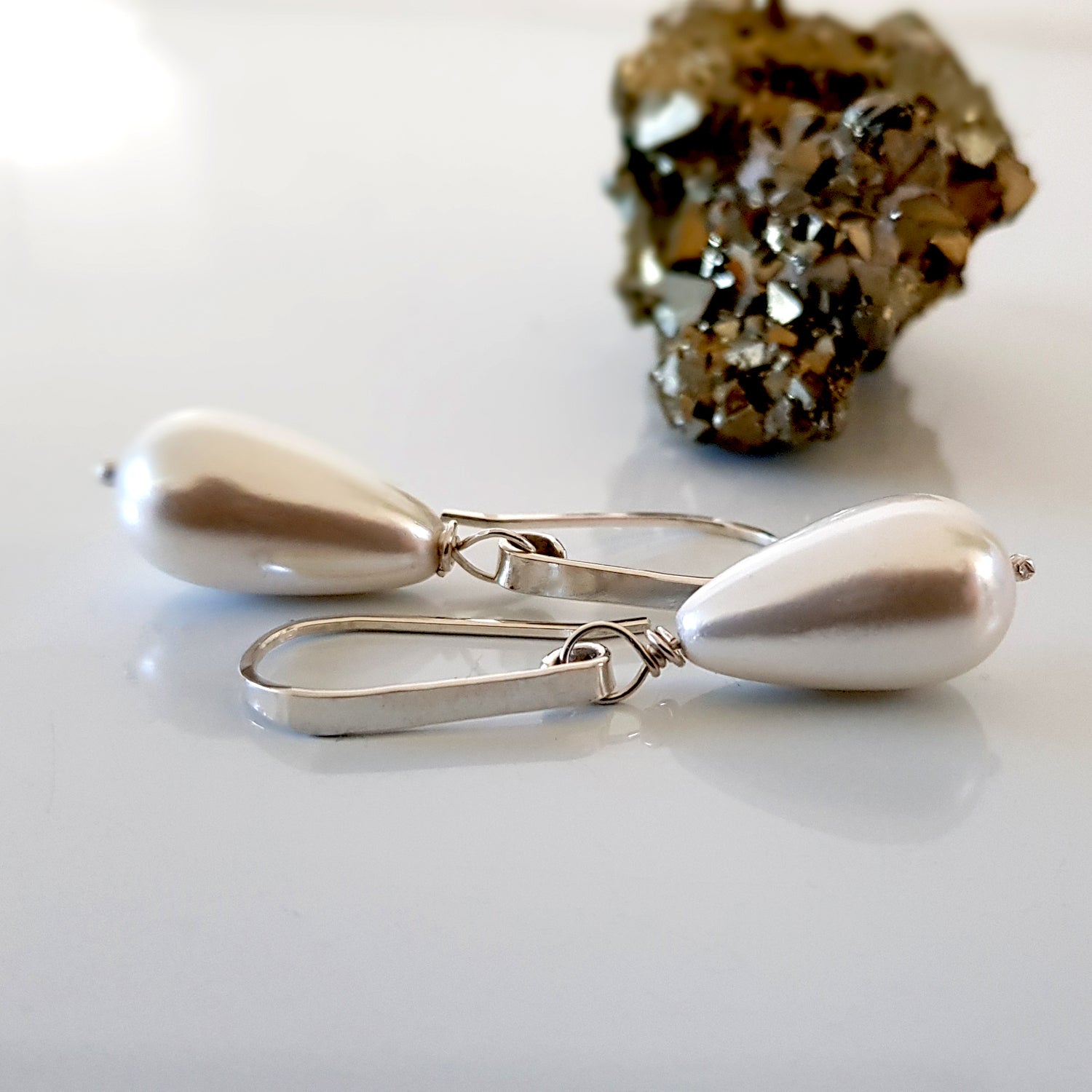 Maroon Smudge Dew Drop teardrop shell pearl earrings featuring elegant, lustrous shells hanging from silver hooks.