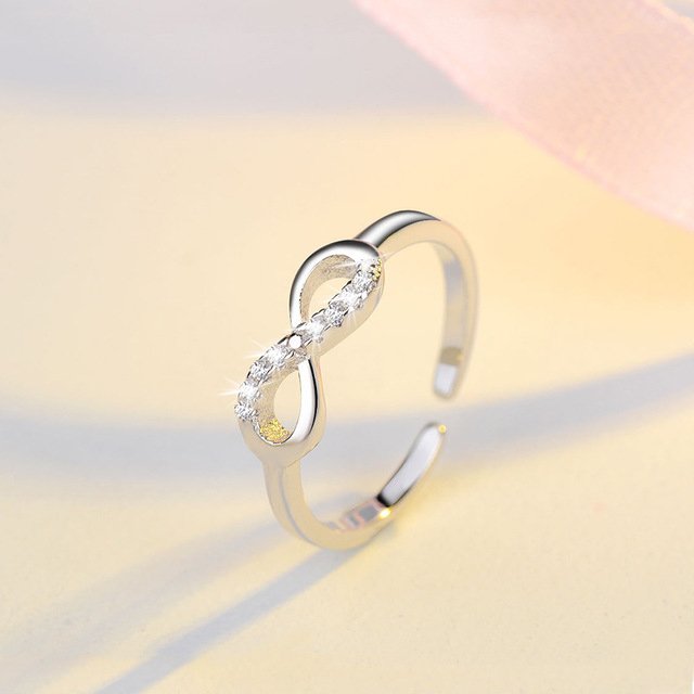 Silver infinity ring with rhinestone accents from Fuchsia Molly, showcasing the detailed design and sparkling embellishments.
