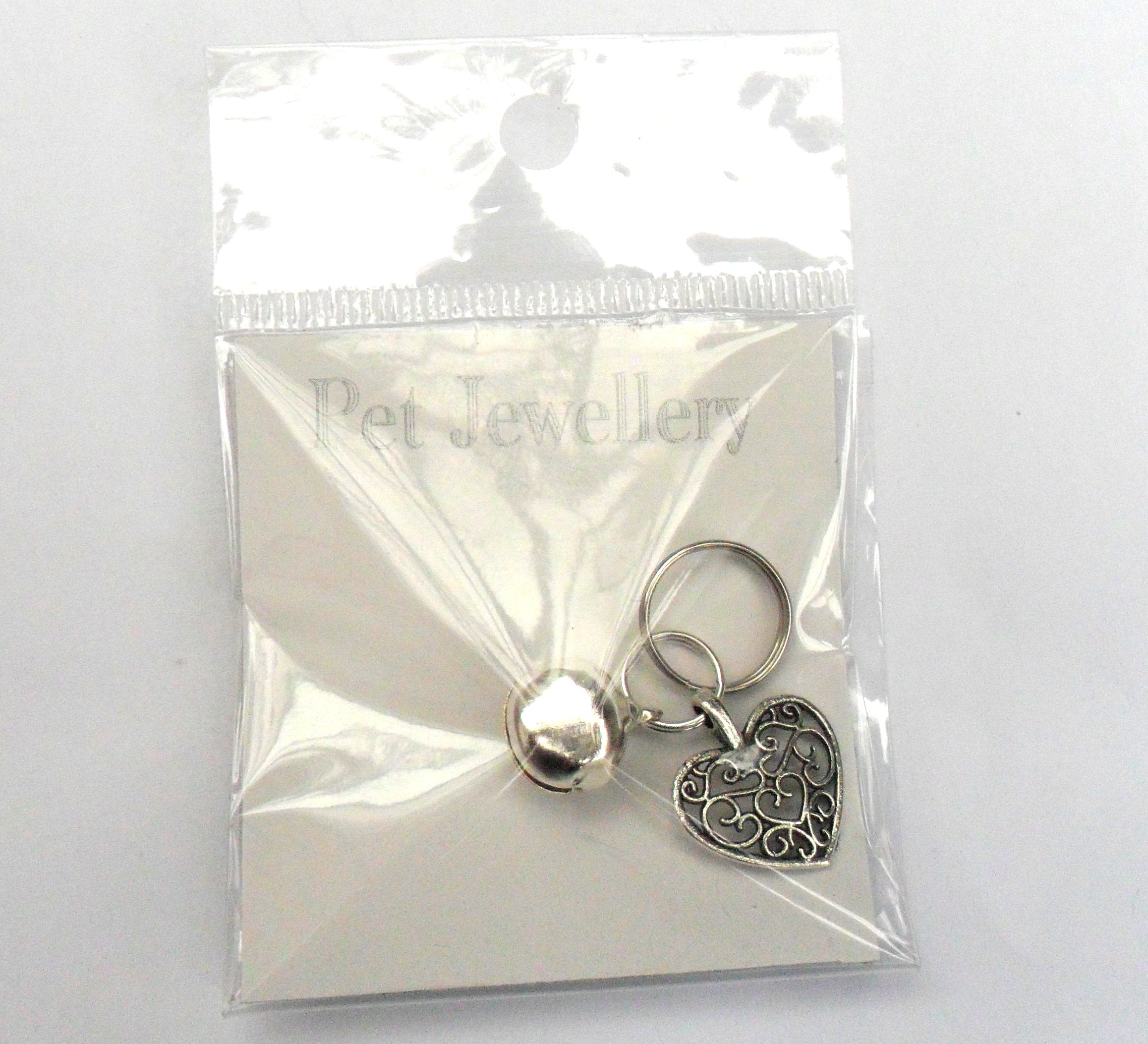 Salmon Oscar filigree heart pet charm attached to a collar, showcasing intricate metalwork on a leather leash for dogs or cats.