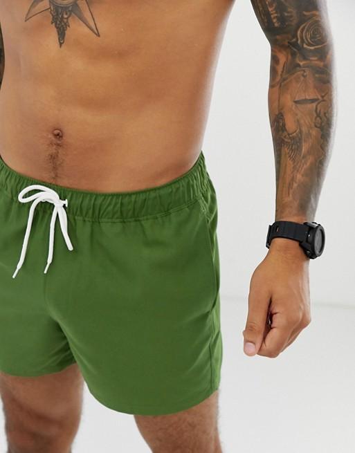 Forest green swim shorts by Sky Felix, displayed flat with elastic waistband and side pockets, suitable for beach or poolwear.